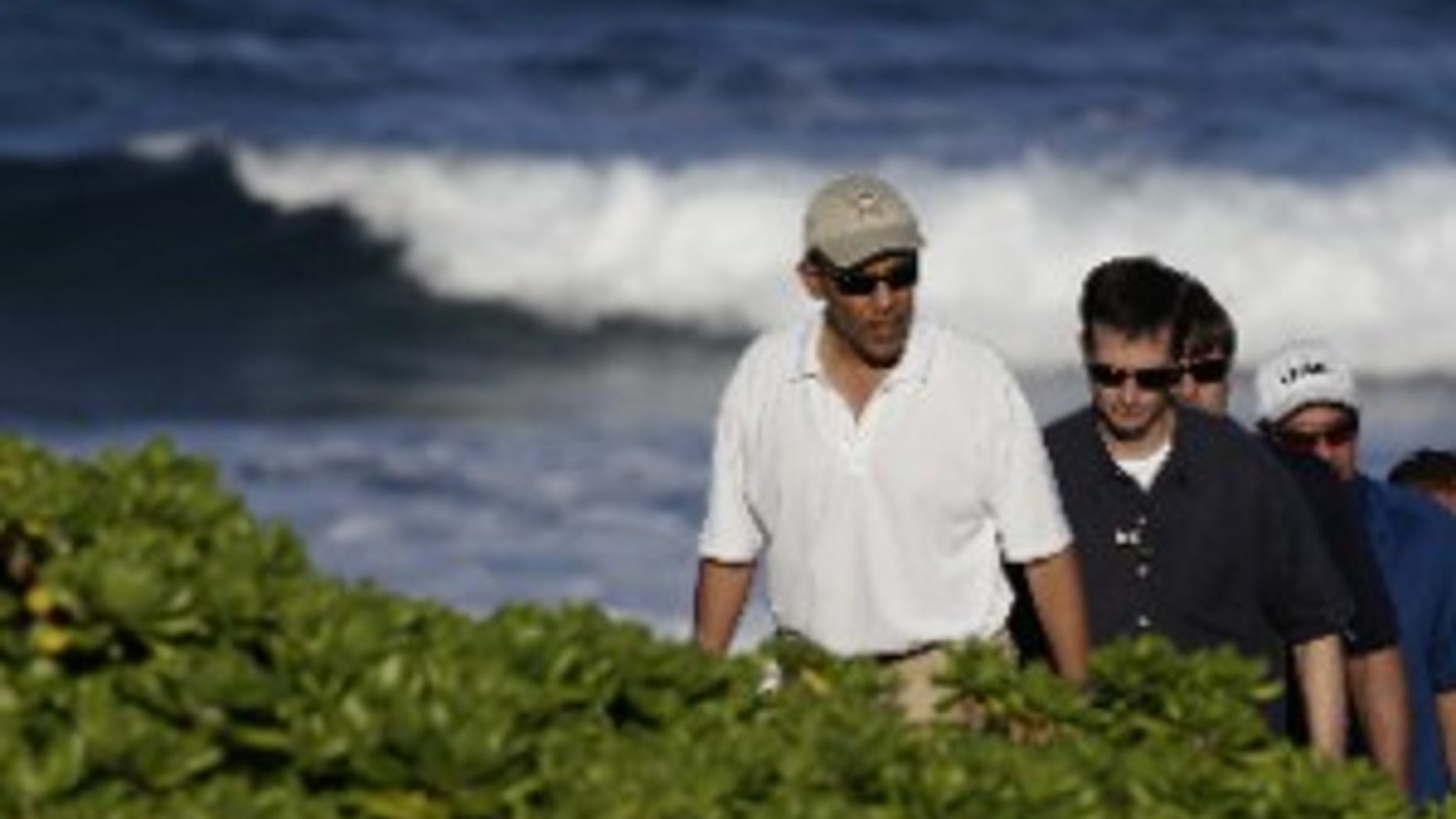 President Barack Obama, left, walks on Pyramid Rock beach on Marine Corps Base Hawaii in Kaneohe Bay, Hawaii Saturday, Dec. 26, 2009. The Obamas are in Hawaii for the holidays.(AP Photo/Alex Brandon)