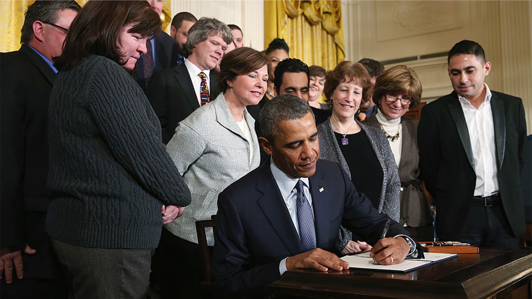 U.S. President Barack Obama jokes with guests before signing a presidential memorandum for modernizing overtime protections for workers during an event in the East Room of the White House, on March 13, 2014 in Washington, DC. The memorandum will direct the Secretary of Labor to begin the process of addressing overtime pay protections to make sure millions of workers are paid a fairly. (Photo by Mark Wilson/Getty Images)