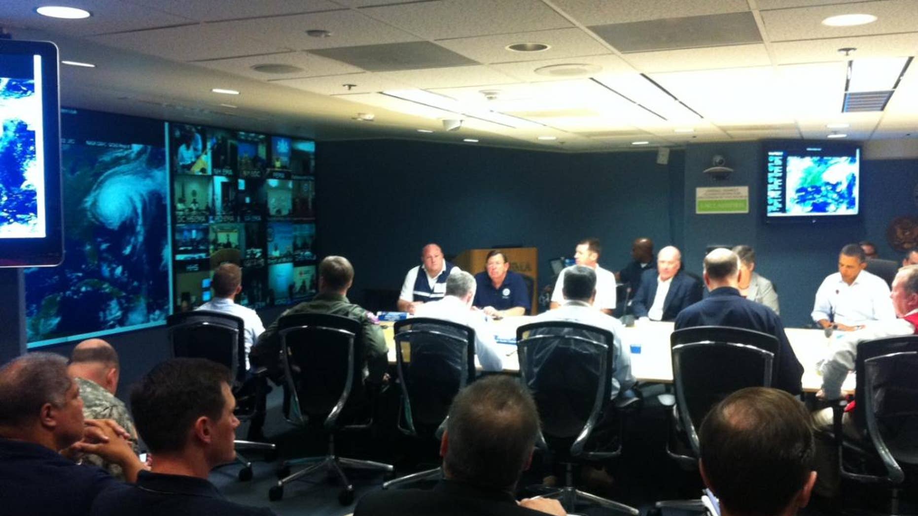 President Obama participates in a conference call on Hurricane Irene. The storm's image can be seen on a screen to the left. (Press pool photo)
