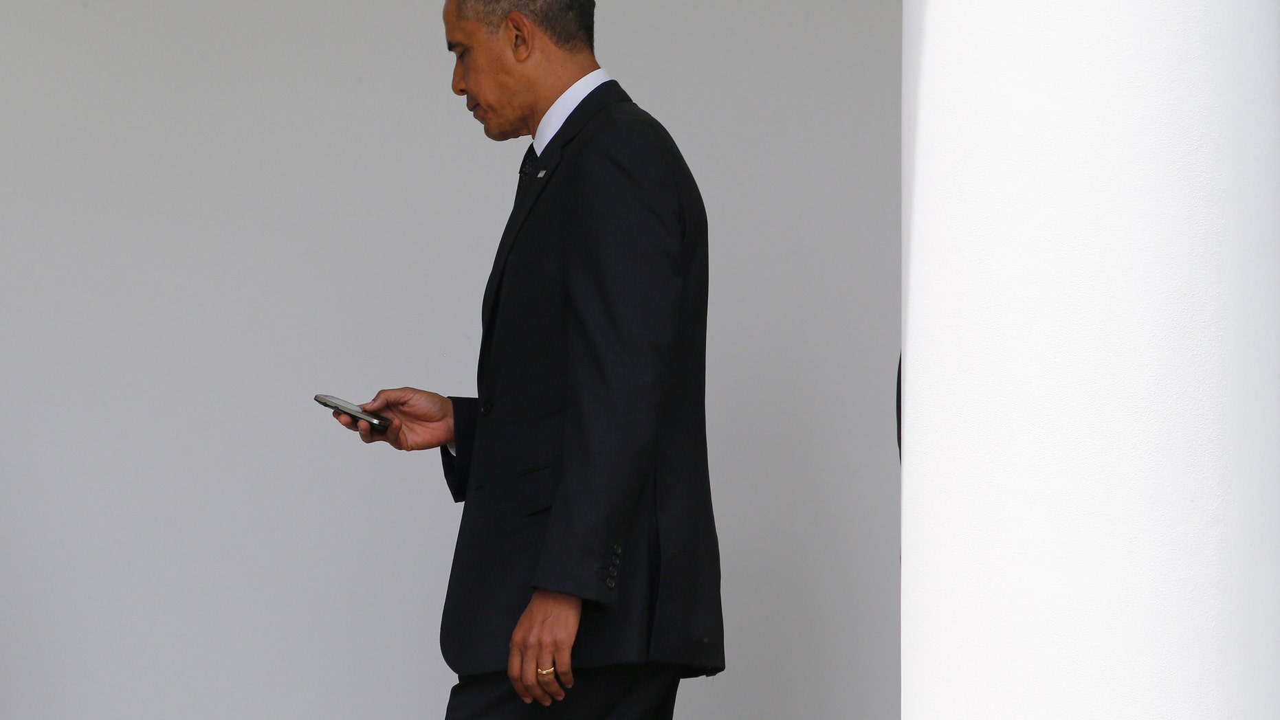 File photo - President Barack Obama checks his Blackberry smartphone.