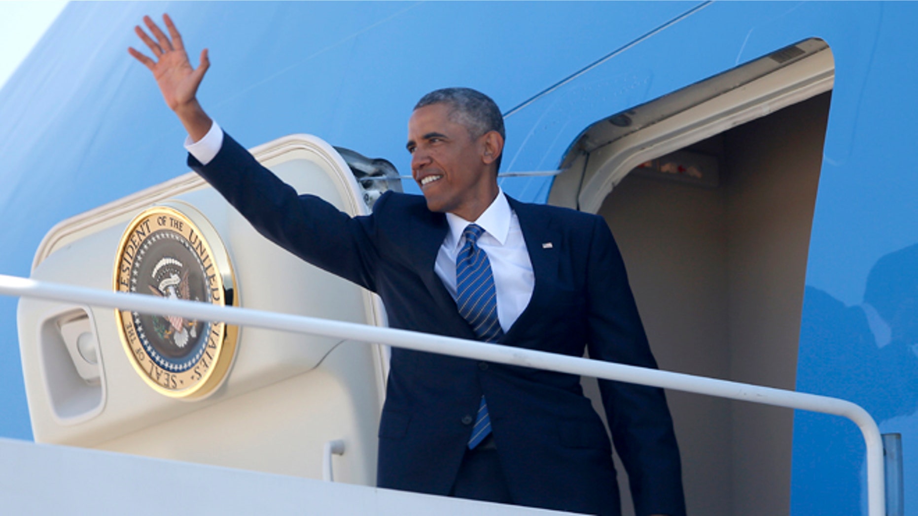 President Obama waves as he boards Air Force One at Andrews Air Force Base, Md., Tuesday, Aug. 26, 2014.