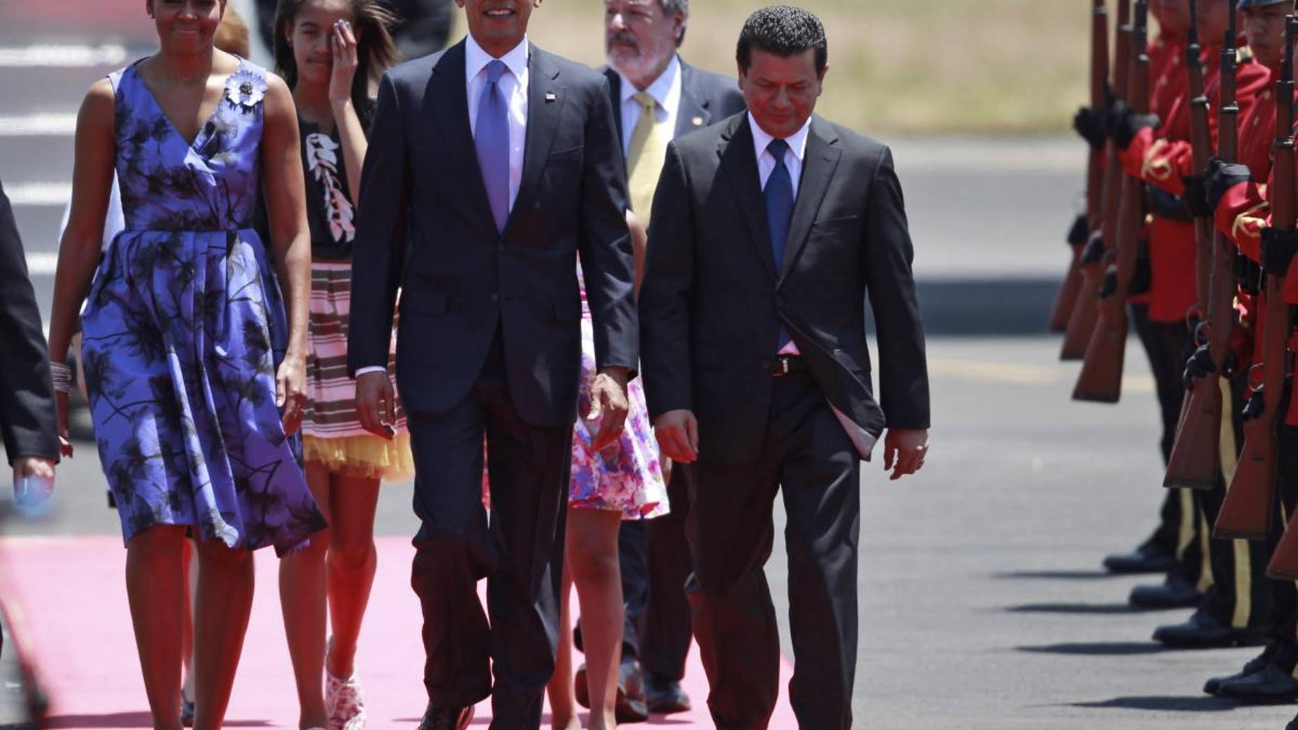 President Barack Obama, accompanied by his wife Michelle Obama and his daughters, walks upon his arrival to the international airport in San Salvador, El Salvador, Tuesday March 22, 2011. (Photo/Dario Lopez-Mills)