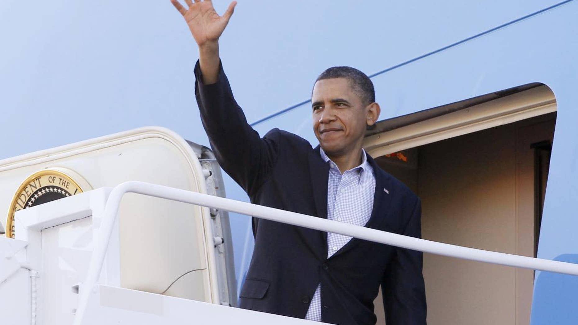 President Barack Obama waves as he boards Air Force One at Hickam Air Force Base in Honolulu, Tuesday, Nov. 15, 2011, as he travels to Canberra, Australia. (AP Photo/Charles Dharapak)