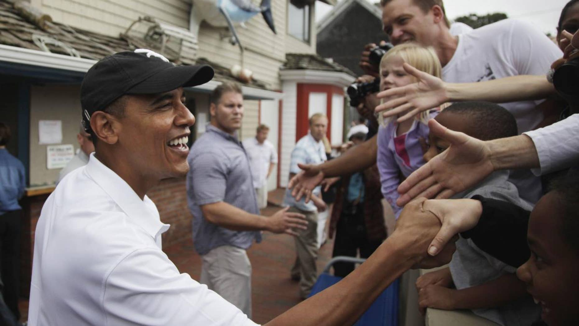 (AP File Photo Aug. 25, 2010) President Barack Obama greets people gathered outside Nancy's Restaurant in Oak Bluffs on Martha's Vineyard, Mass. He will vacation with his family in Martha's Vineyard at the end of this month as he's done in years past, the White House said Wednesday.