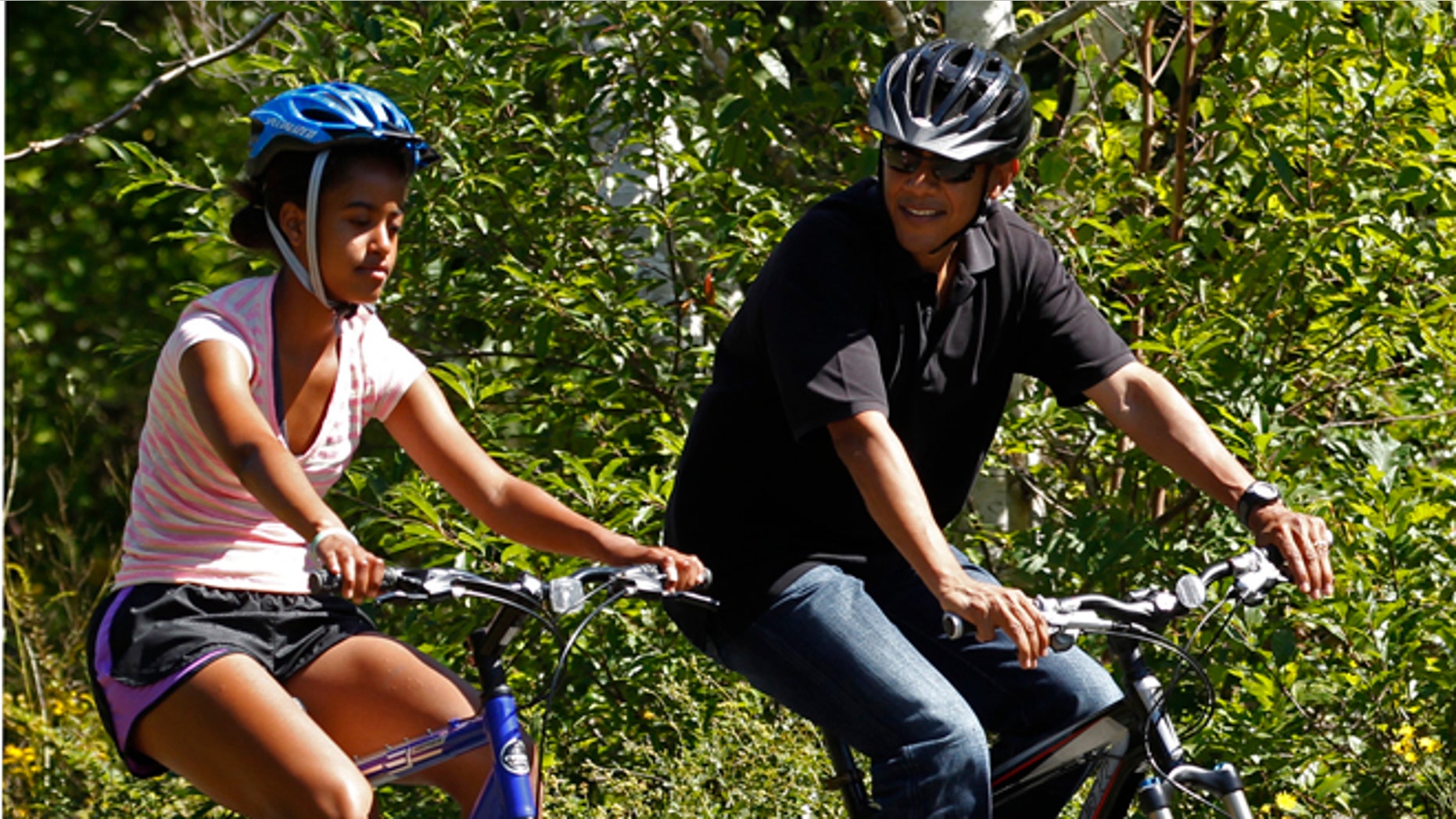 FILE: August 23, 2011: President Obama bikes with daughter Malia during their family vacation on Martha's Vineyard in Massachusetts.