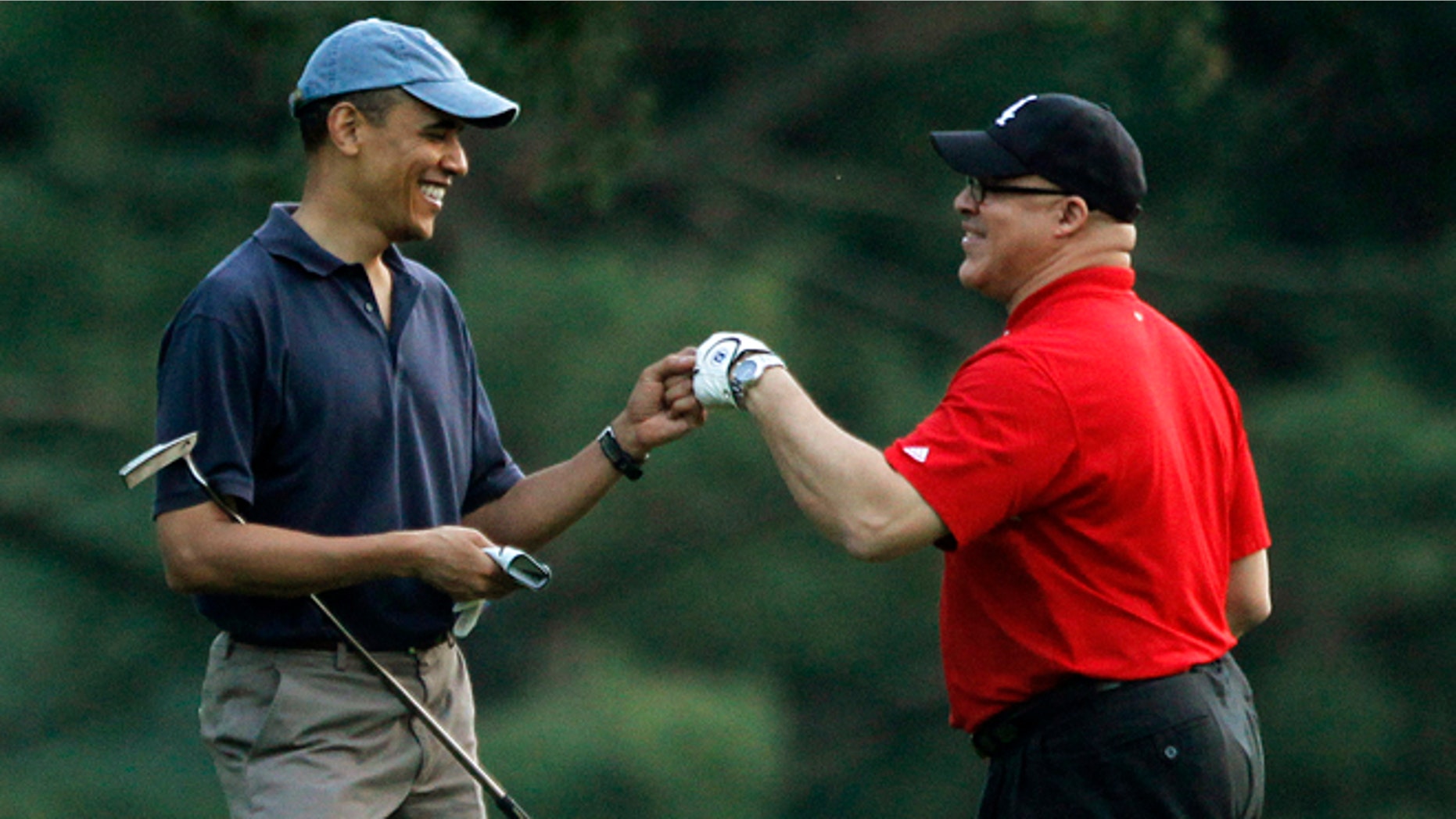 In this April 23, 2010 file photo, President Obama plays golf with Eric Whitaker at the Grove Park Inn Resort in Asheville, North Carolina.