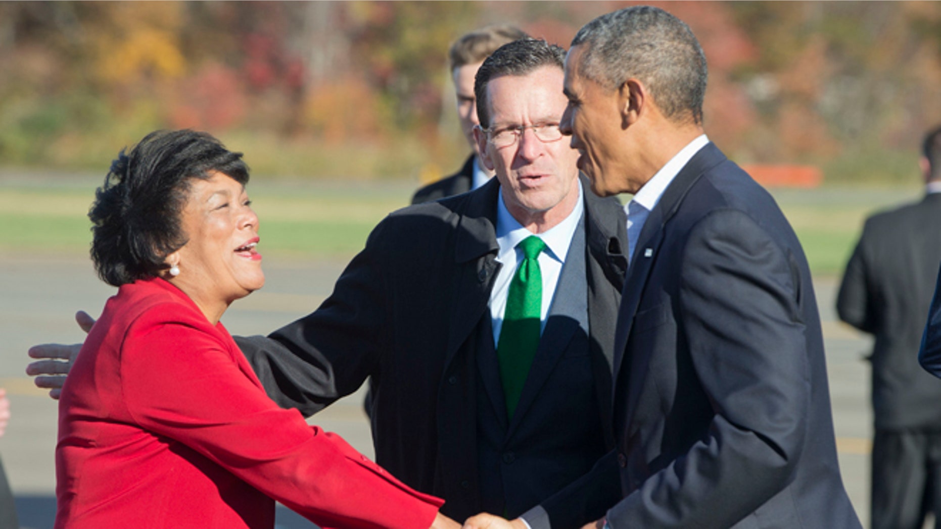 President Obama, right, is greeted by Gov. Dan Malloy, center, and New Haven Mayor Toni Harp, at Tweed New Haven Airport, in Connecticut.
