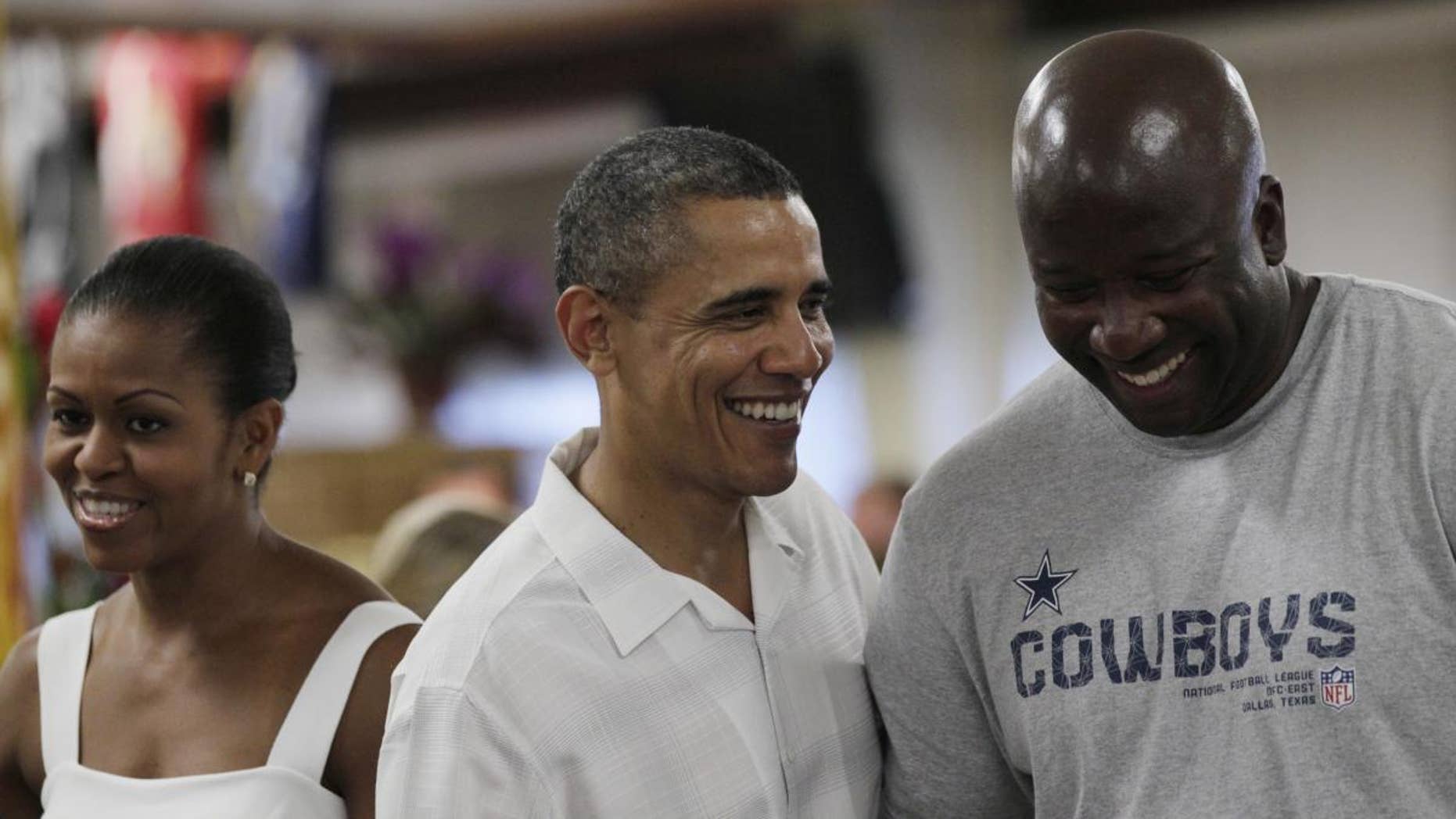 President Barack Obama, with first lady Michelle Obama, laughs with a member of the military during Christmas dinner at Anderson Hall on Marine Corps Base Hawaii in Kaneohe, Hawaii, Saturday, Dec. 25, 2010. The first family is in Hawaii for the holidays. (AP Photo/Carolyn Kaster)