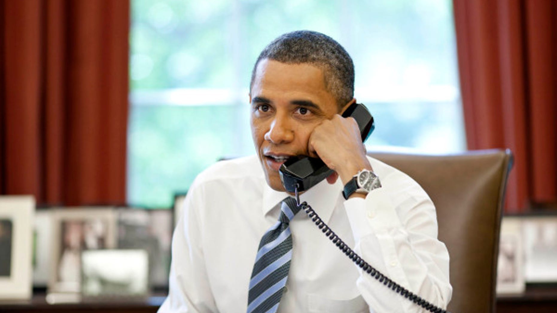 President Barack Obama talks with the crews of the Space Shuttle Atlantis and the International Space Station during a phone call in the Oval Office, July 15, 2011. (Official White House Photo by Pete Souza)