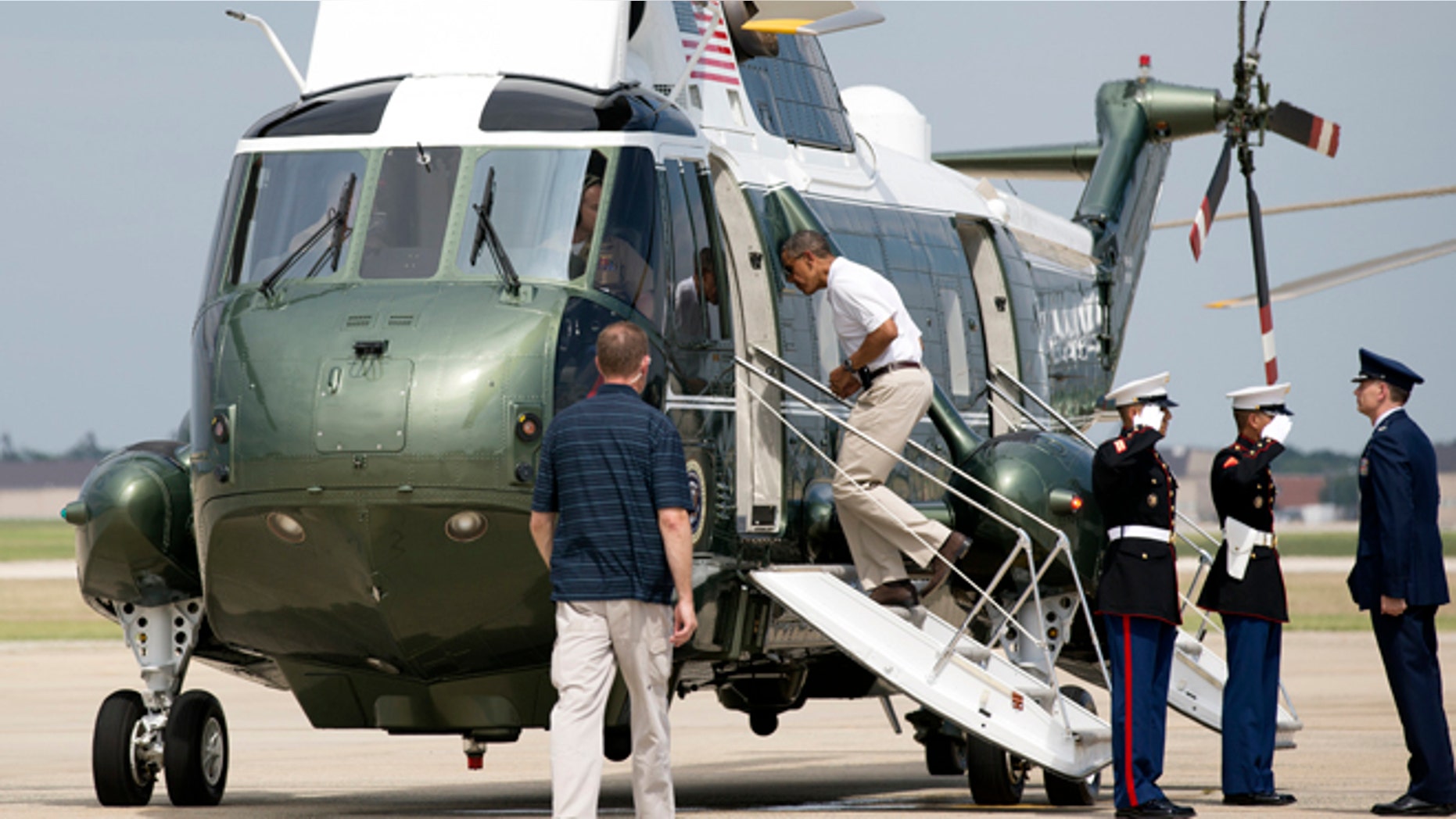 Aug 3, 2013: President Barack Obama, second from left, jogs up the ramp of Marine One as he leaves Andrews Air Force Base, Md., for a weekend in Camp David.