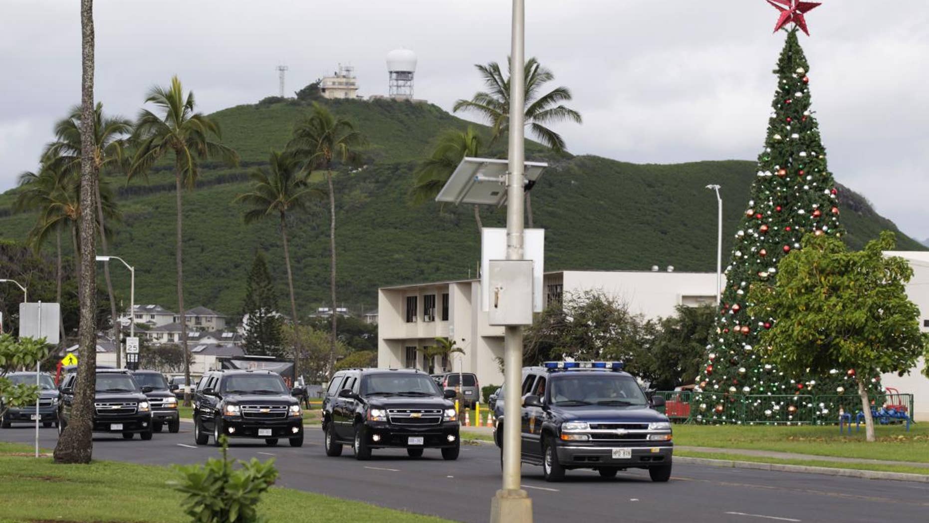 President Barack Obama and first lady Michelle Obama travel by motorcade on Marine Corps Base Hawaii in Kaneohe, Hawaii, Monday, Dec. 27, 2010. (AP Photo/Carolyn Kaster)