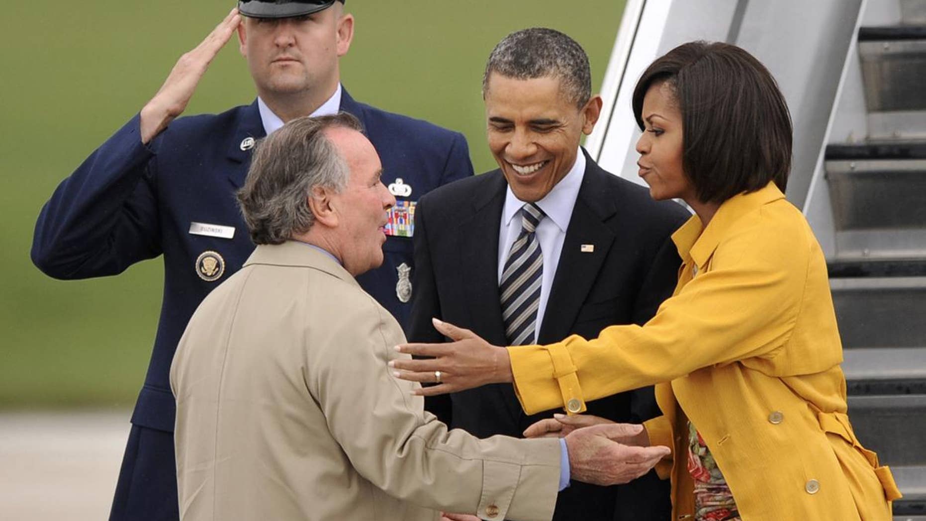 President Barack Obama and first lady Michelle Obama are greeted by Chicago Mayor Richard M. Daley upon their arrival at Chicago O'Hare International Airport in Chicago, Wednesday, April 27, 2011. (AP Photo/Paul Beaty)