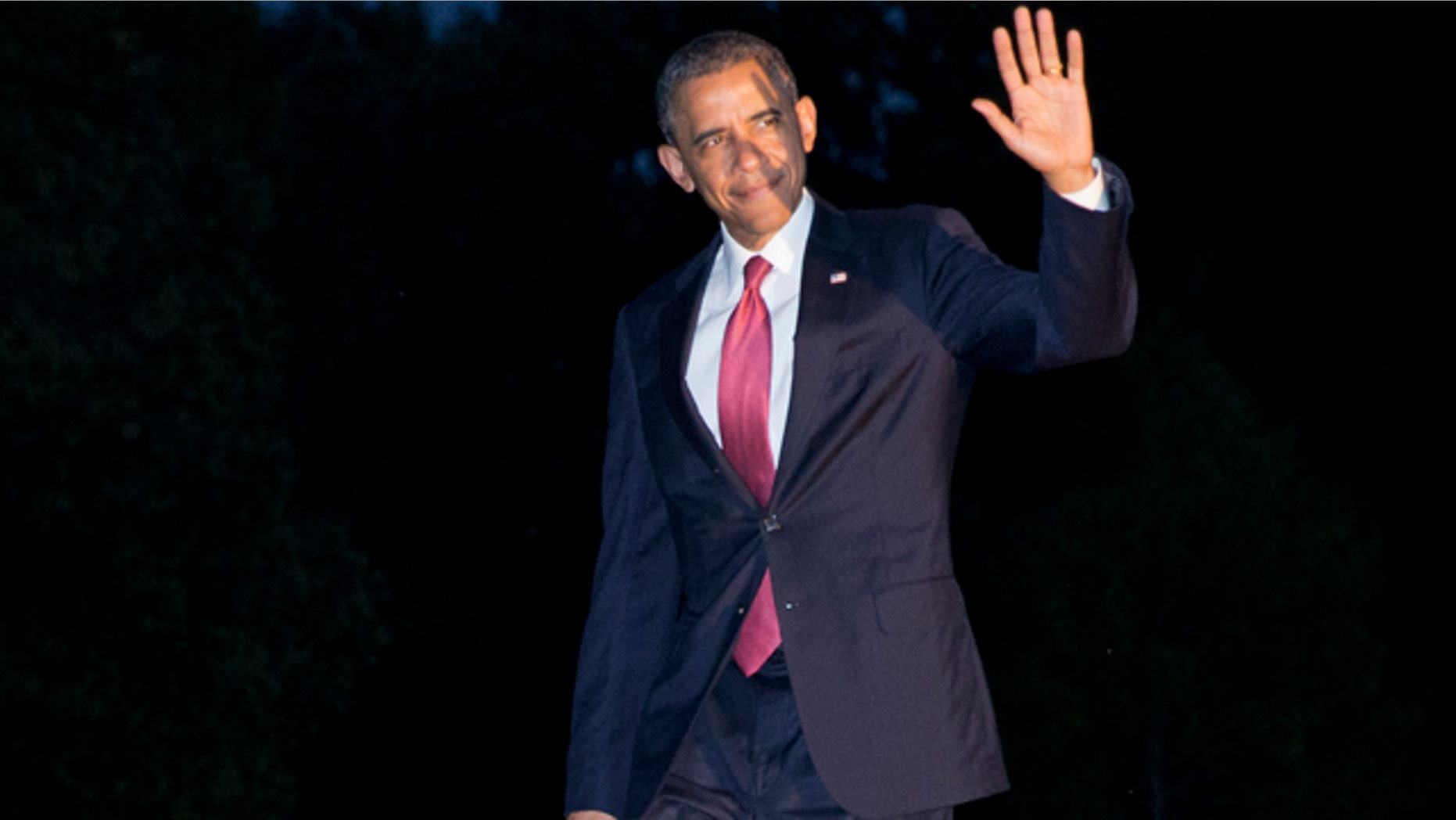 June 6, 2014: President Barack Obama waves to the media as he returns at dusk on the South Lawn of the White House in Washington after attending remembrance activities on the 70th anniversary of D-Day in Normandy, France. (AP Photo/Jacquelyn Martin)