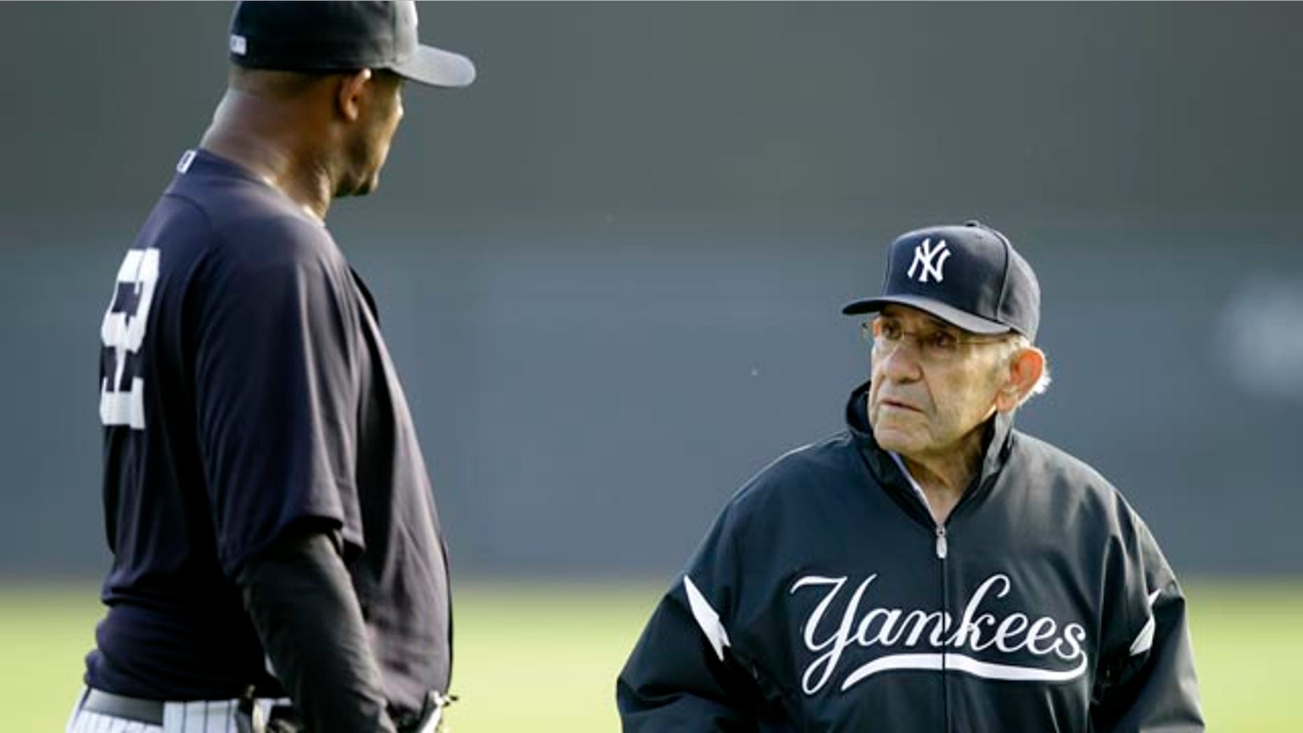 File-This Feb. 24, 2011, file photo shows New York Yankees pitcher CC Sabathia,left, talking with Yogi Berra, right, during a baseball spring training workout at Steinbrenner Field in Tampa, Fla. (AP Photo/Charlie Neibergall, File)