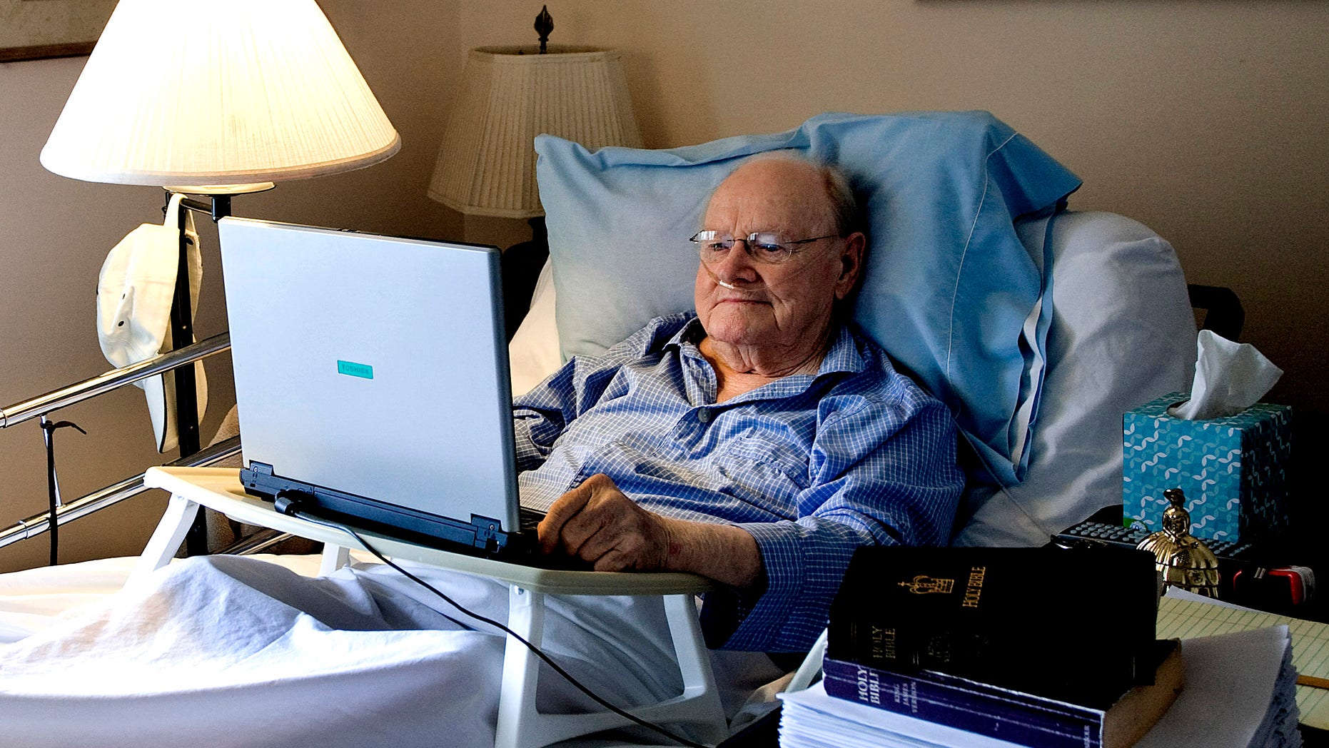 In this Aug. 25, 2012 photo, Gene Patterson, former chairman and chief executive of the Times Publishing Company and its affiliates, checks his email from his bed in St. Petersburg, Fla. Patterson edited 600,000 words out of the King James Bible shown at right, sitting on top of his finished manuscript. Newspaper editor and columnist Eugene Patterson, who helped fellow Southern whites understand the civil rights movement, has died, Saturday, Jan. 12, 2013. He was 89. (AP Photo/The Tampa Bay Times, Cherie Diez) TAMPA OUT; CITRUS COUNTY OUT; PORT CHARLOTTE OUT; BROOKSVILLE HERNANDO TODAY OUT