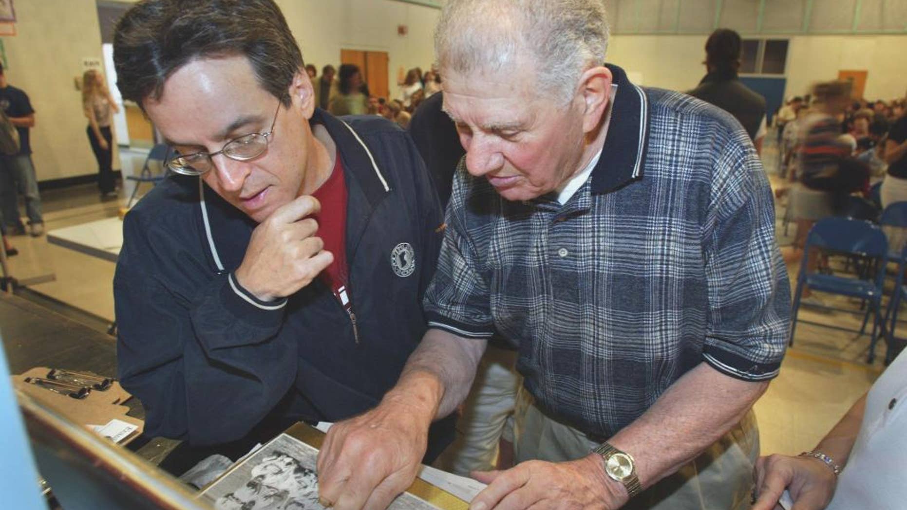 FILE - In this May 31, 2003, file photo, screenwriter Angelo Pizzo, left, looks at some old photos with former United States soccer player Frank Borghi at Shaw School during a casting call for the movie "The Game of Their Lives," in St. Louis. Borghi, the goalkeeper in the United States' 1-0 upset victory over England in the 1950 World Cup, died Monday, Feb. 2, 2015, according to the St. Louis Soccer Hall of Fame. He was 89. (AP Photo/St. Louis Post-Dispatch, Teak Phillips, File) EDWARDSVILLE INTELLIGENCER OUT; THE ALTON TELEGRAPH OUT