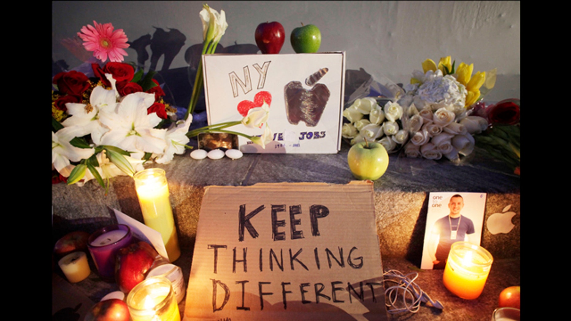 Candles illuminate a memorial to Apple co-founder Steve Jobs, Thursday, Oct. 6, 2011 in front of an Apple store in New York. Jobs died Wednesday at 56.