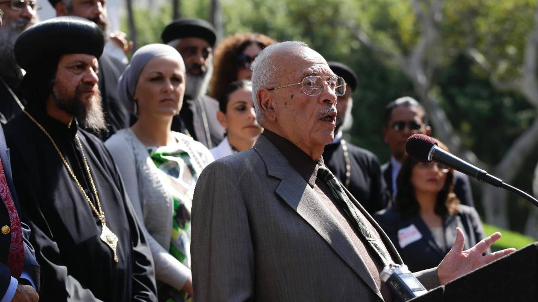 FILE - In this Sept. 17, 2012, file photo, Dr. Maher Hathout, Senior Adviser of the Muslim Public Affairs Council, center, speaks in Los Angeles to condemn all violent reactions in the Middle East. Hathout, a prominent interfaith leader, hailed as the father of the American Muslim identity, has died at age 79. Salam al-Marayati, president of the Muslim Public Affairs Council that Hathout co-founded, says Hathout died Friday, Jan. 2, 2015, after a yearlong battle with liver cancer. (AP Photo/Chris Carlson, File)