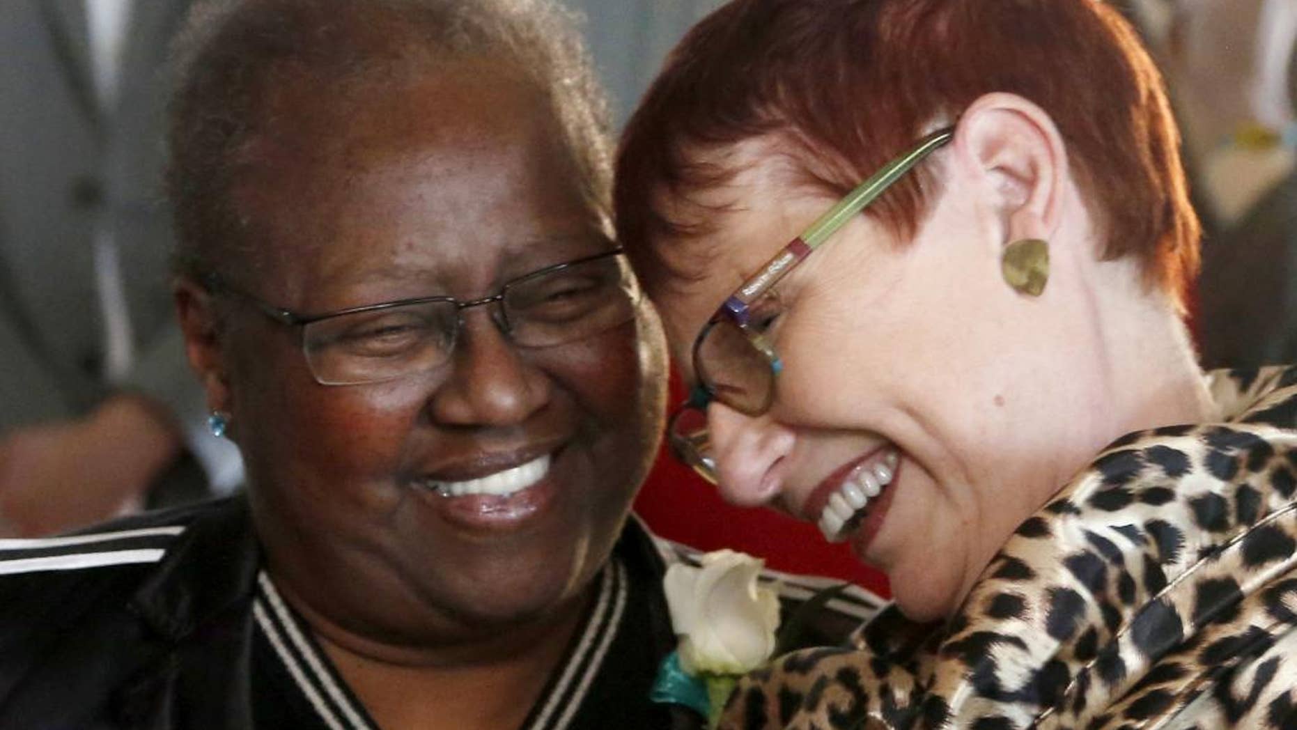 FILE - In this Nov. 27, 2013 file photo, Vernita Gray, left, and Patricia Ewert, smile after their wedding ceremony in Chicago. They were the first couple to be married after the gay marriage law was signed by the governor. Because Gray was terminally ill, they were issued an expedited marriage license before the state's gay marriage law took effect in June 2014. A family friend says Vernita Gray died late Tuesday, March 18, 2014, of cancer. She was 65. (AP Photo/Charles Rex Arbogast, File)