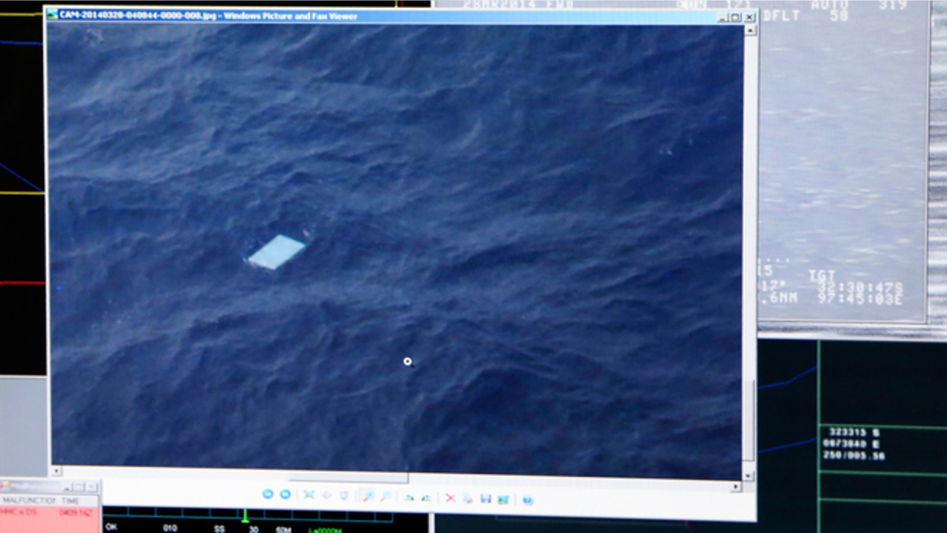 A photo taken off a computer monitor onboard a Royal New Zealand Air Force P-3 Orion, shows an object floating in an area within the search zone of the missing Malaysia Airlines Flight 370 in the Southern Indian Ocean off the coast of Western Australia, Friday, March 28, 2014. Australian Maritime Safety Authority has not confirmed any information about this object. Australian officials said that objects spotted floating in the search area need to be recovered and inspected before they can be linked to the plane. The objects, first spotted Friday, include two rectangular items that were blue and gray, and ships on the scene will attempt to recover them, the AMSA said. (AP Photo/Tony Cheng, Pool)