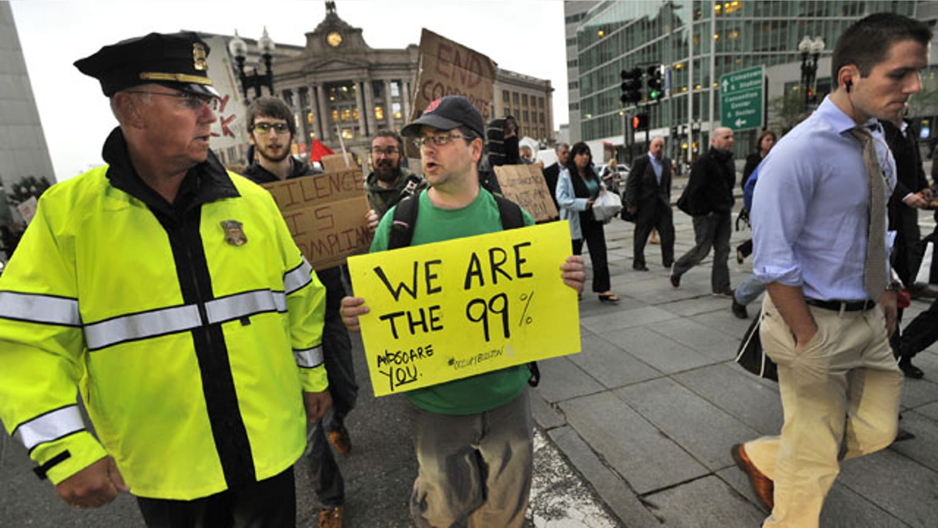 October 3: A marcher speaks with a police officer as they cross a street alongside morning commuters as the marchers set out from the Occupy Boston encampment in Dewey Square in front of the Federal Reserve building, in Boston.