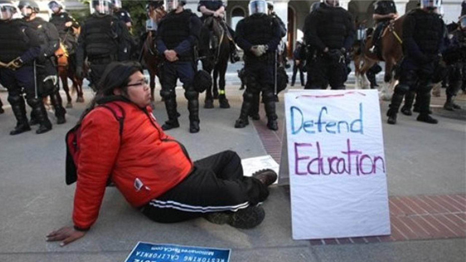 March 5, 2012: Derrick, a member of Occupy San Francisco, sits in front of California Highway Patrol officers dressed in riot gear during a demonstration against cuts to higher education held at the Capitol in Sacramento, Calif.