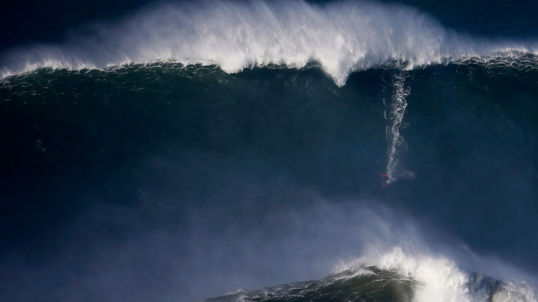File photo - A surfer drops in on a large wave at Praia do Norte, in Nazare Dec. 11, 2014.