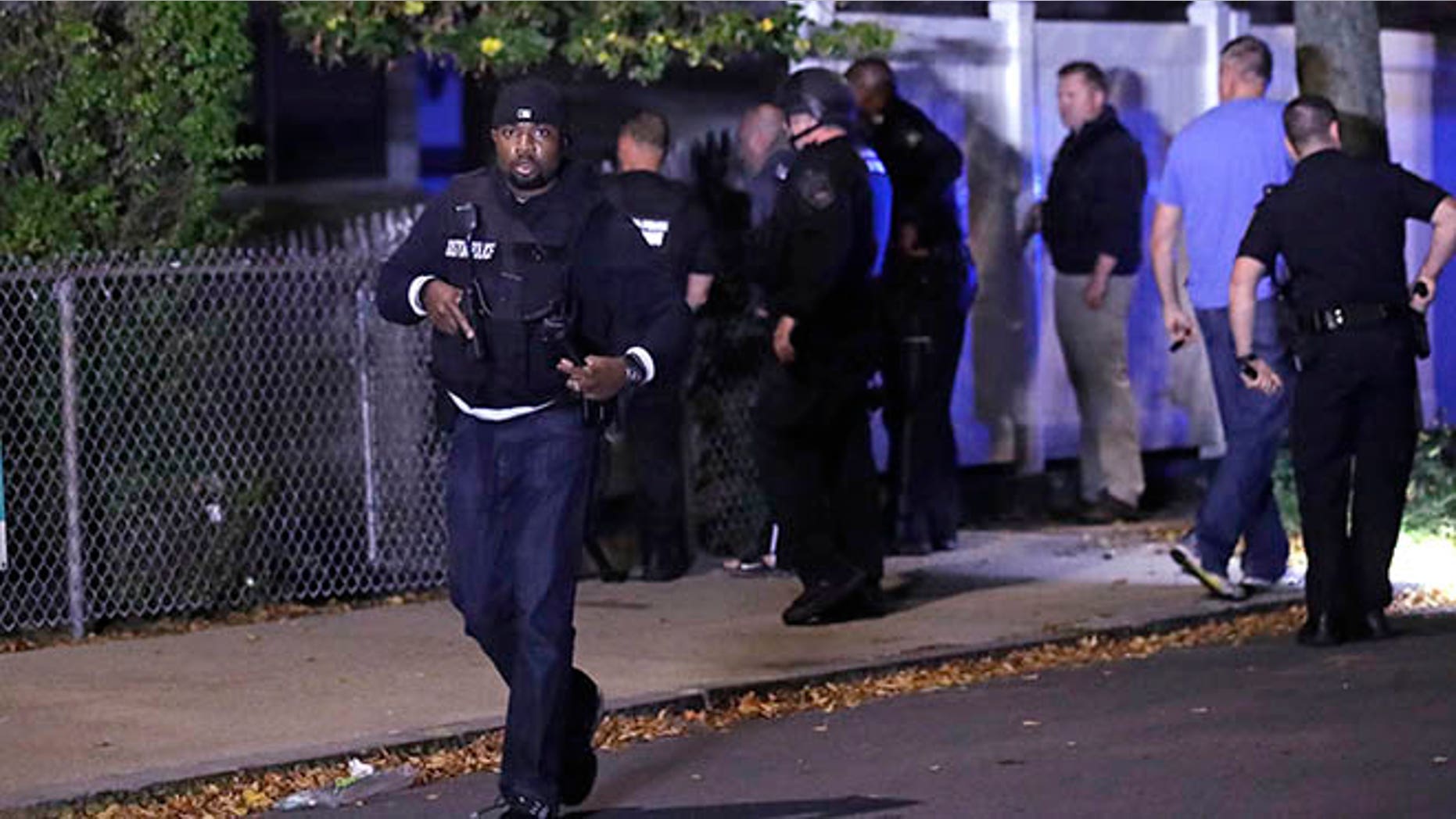 Police search for a suspect after a shooting in the East Boston neighborhood of Boston, Wednesday, Oct. 12, 2016. Police say two officers were shot late Wednesday night. Their conditions were not immediately available. It's unclear what led to the shooting. (AP Photo/Charles Krupa)