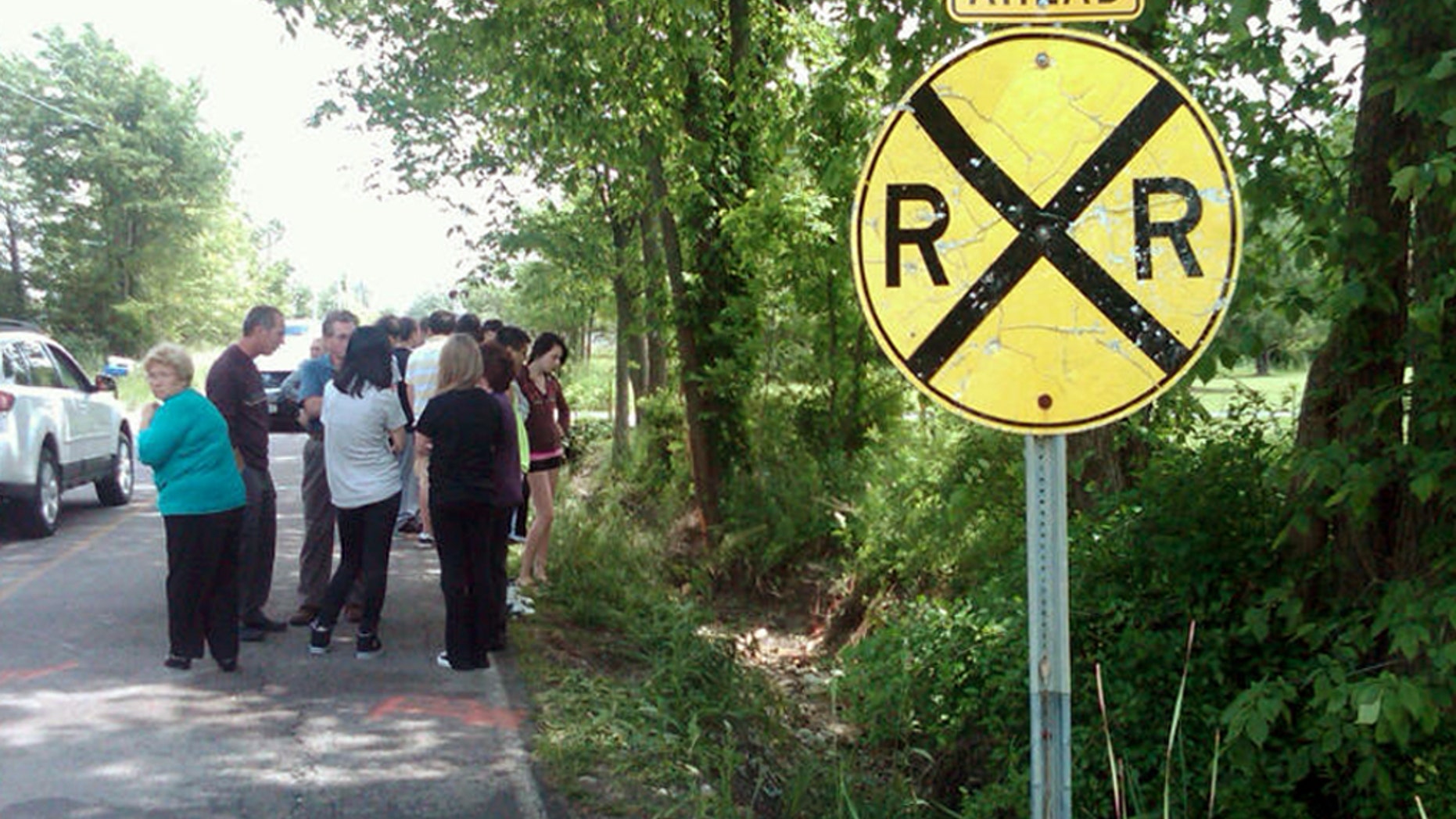 June 3, 2012: People gather at the scene of an early-morning crash on Boston Road in Lorain County, Ohio to pay their respects and mourn three teens who died there.