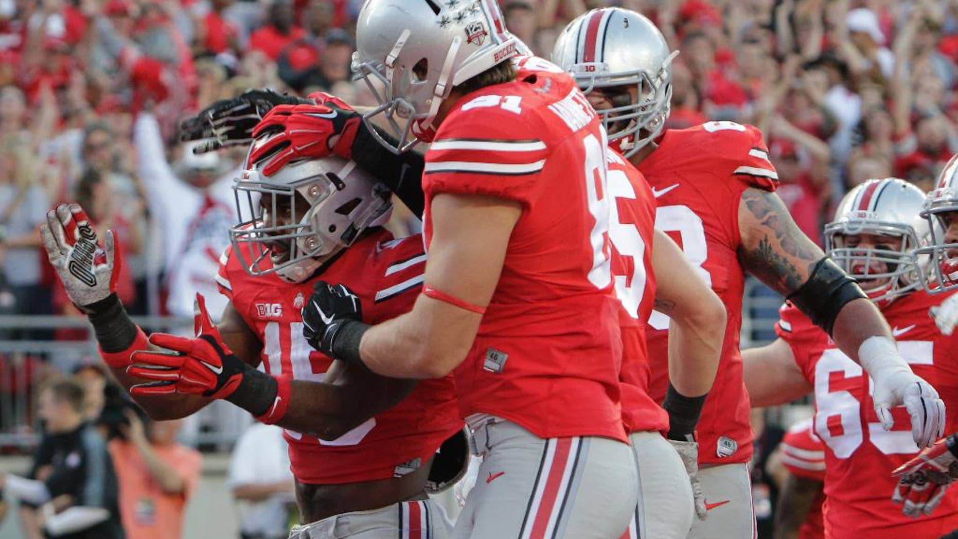 FILE - In this Sept. 27, 2014, file photo, Ohio State running back Ezekiel Elliott, left, celebrates his touchdown against Cincinnati during the first quarter of an NCAA college football game in Columbus, Ohio. All anyone wants to talk about on sports call-in shows in Ohio's capital city is No. 20 Ohio State's porous pass defense. Yet the offense has scored 116 points and piled up 1,338 yards in its last two games heading into the Big Ten opener against a leaky Maryland defense. (AP Photo/Jay LaPrete, File)