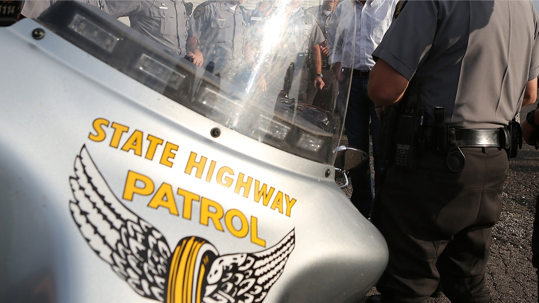 TARLTON, OH - AUGUST 14: Republican presidential candidate and former Massachusetts Governor Mitt Romney (C) meets Ohio State Highway Patrol officers in a church parking lot on August 14, 2012 in Tarlton, Ohio. Mitt Romney is wrapping up his multi state bus tour with campaign events in Ohio. (Photo by Justin Sullivan/Getty Images)