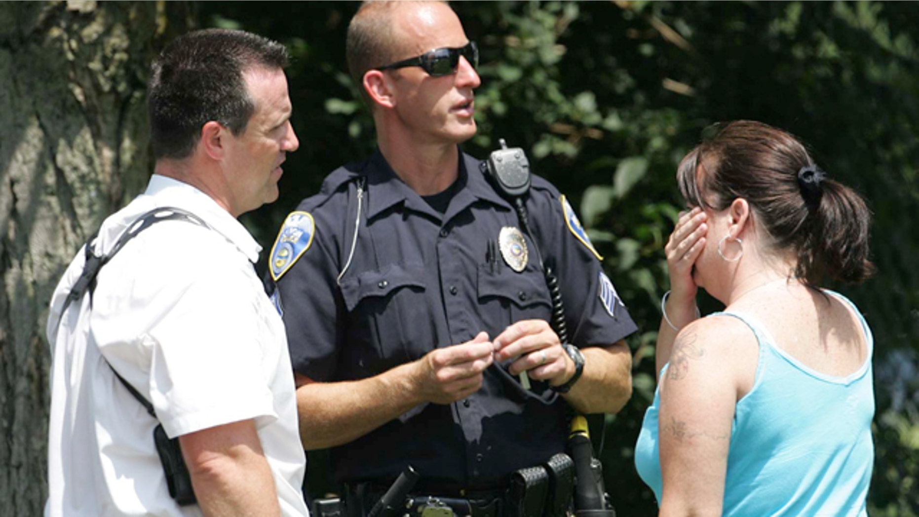 Aug. 7: Members of the Akron Police Department talk to an unidentified woman who claimed to be a relative at the scene of a multiple fatal shooting.