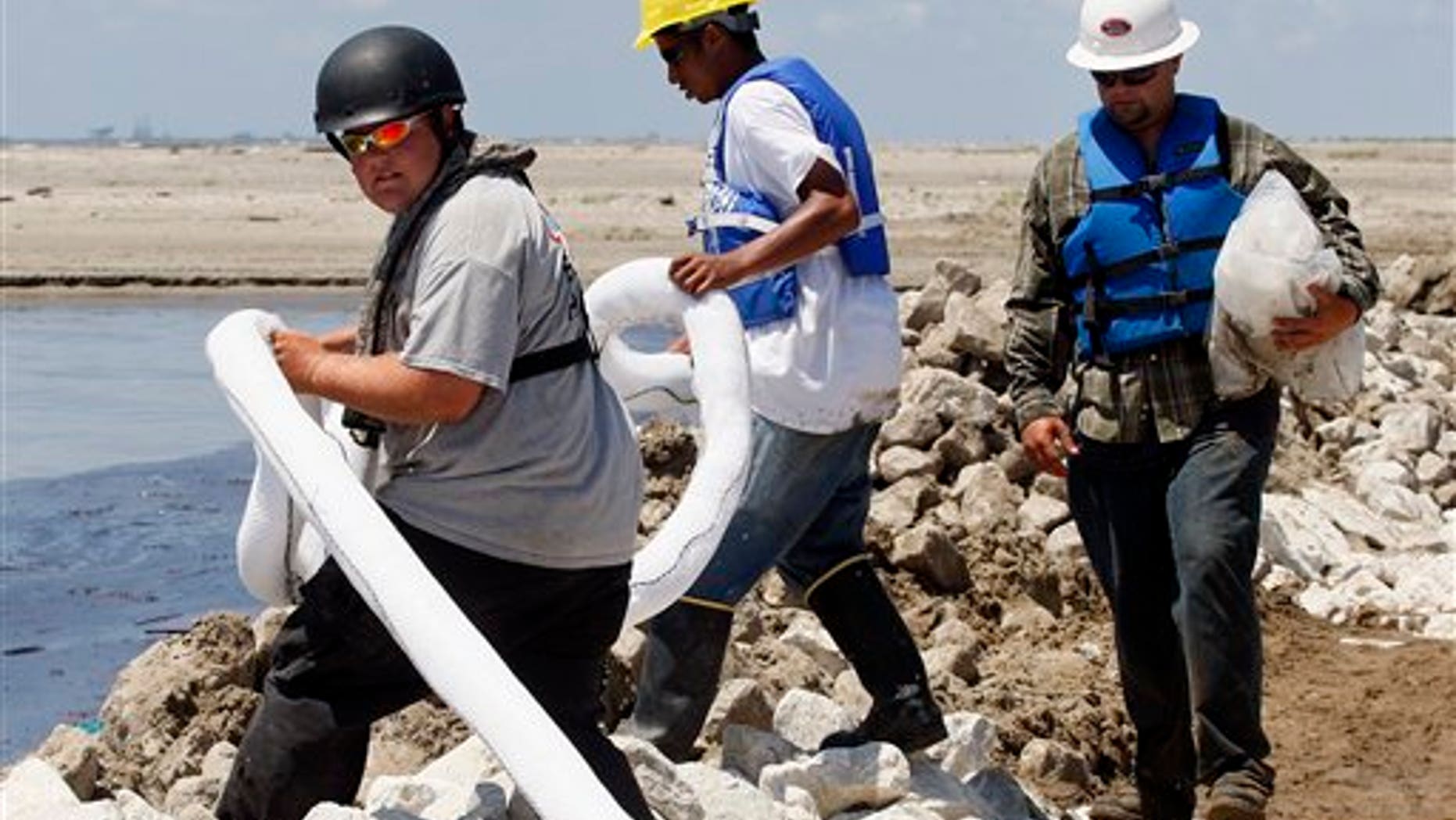 Workers lay oil booms along a land bridge on Elmer's Island in Grand Isle, La., Thursday, May 20, 2010. Oil from last month's Deepwater Horizon oil rig explosion in the Gulf of Mexico has started drifting ashore along the Louisiana coast. (AP Photo/Patrick Semansky)
