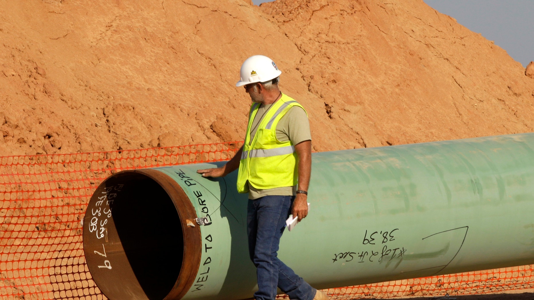 Oct. 4, 2012: A pipeline worker walks the length of a pipe as work continues.