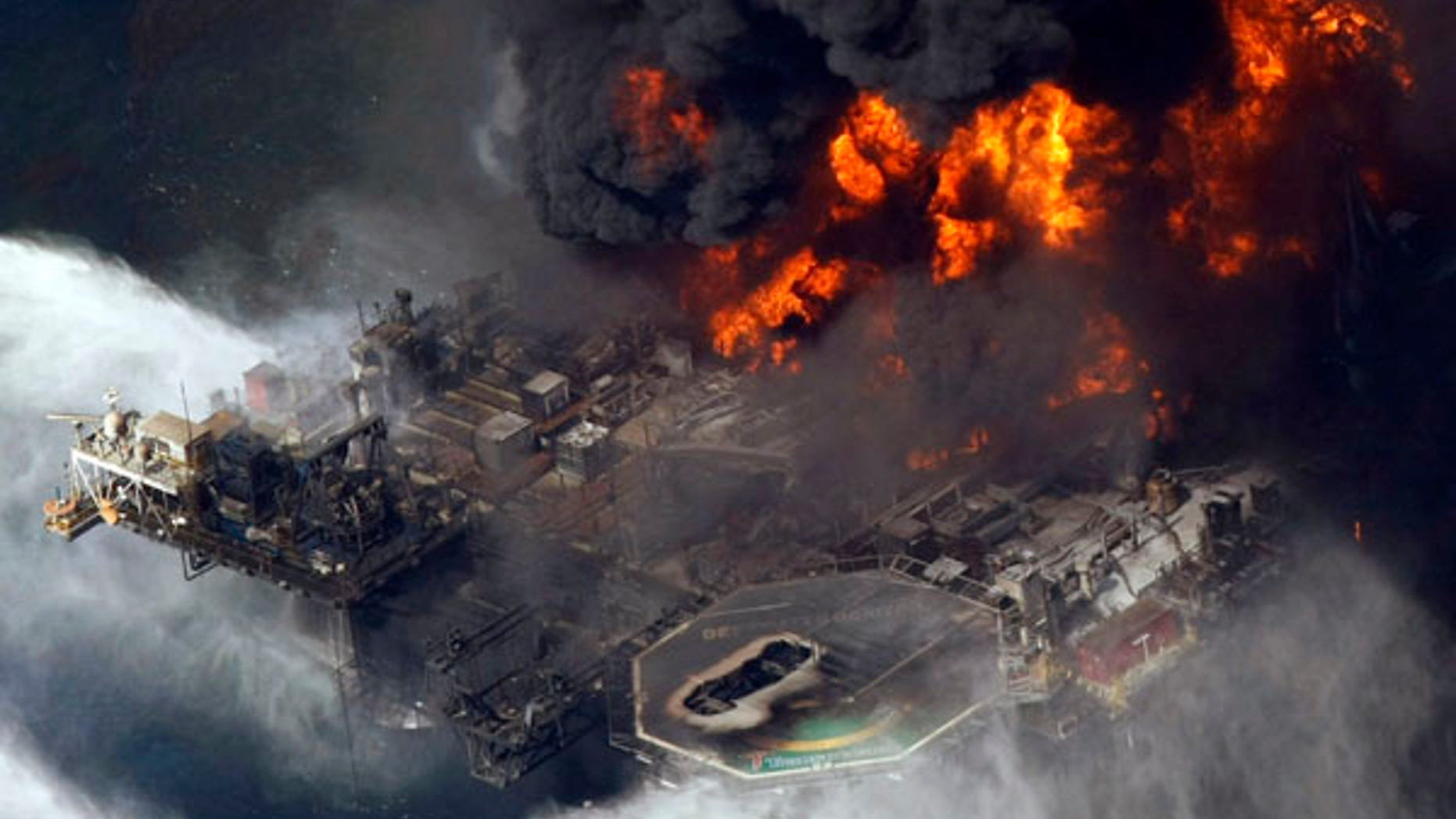 In this April 21, 2010 file aerial photo, the Deepwater Horizon oil rig burns in the Gulf of Mexico more than 50 miles southeast of Venice, La.