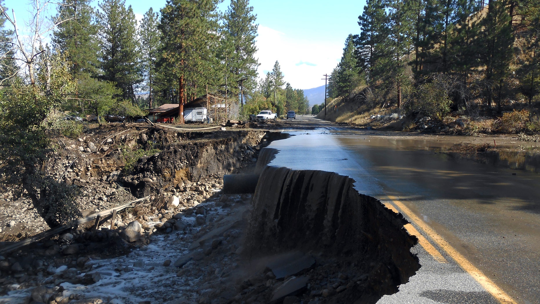 Aug. 22, 2014: Water pours over a damaged road east of Twisp, Wash.