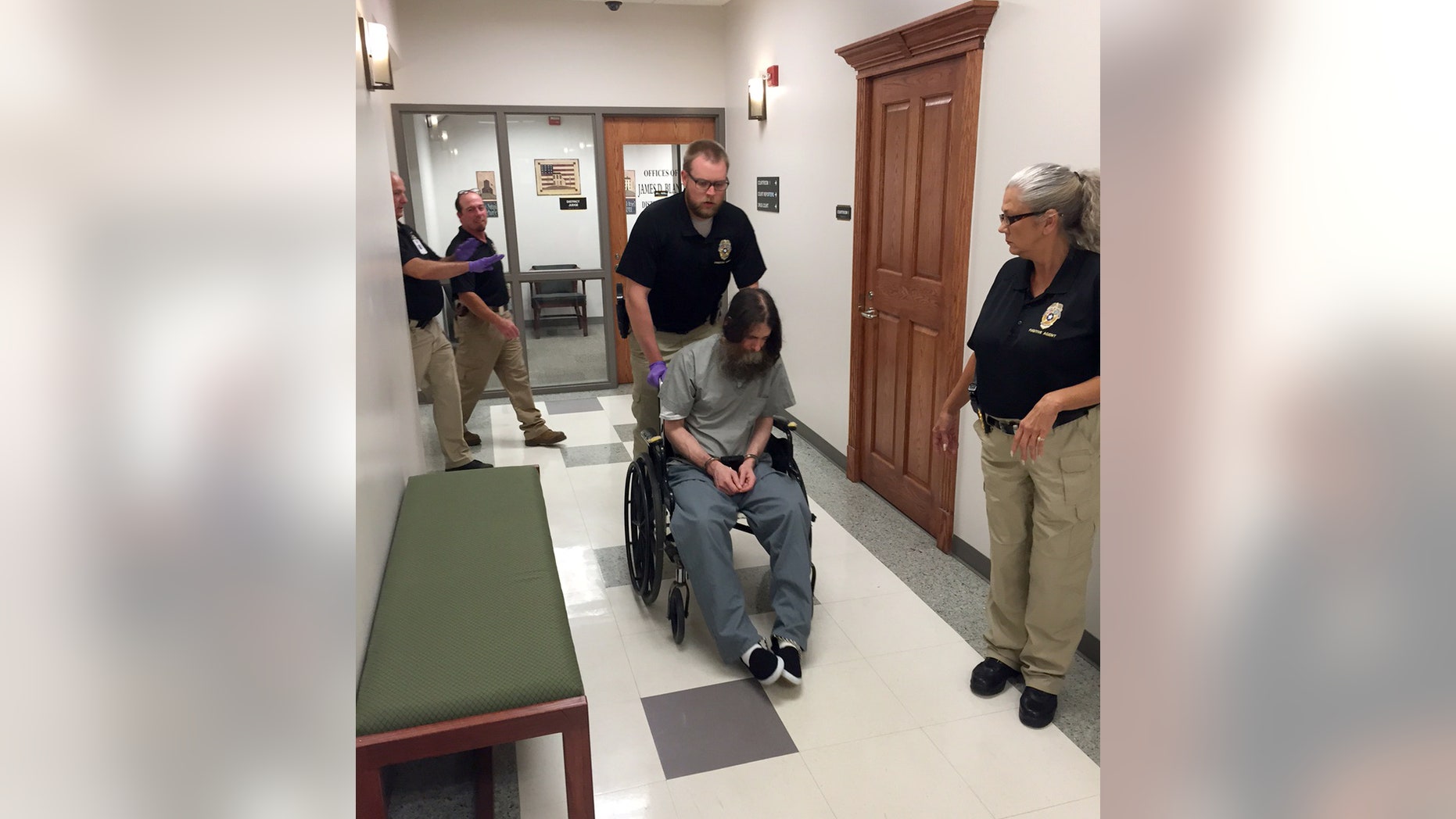 Officials transport Benjamin Robert Cole into a Pittsburg County courtroom, Friday, Aug. 28, 2015, in McAlester, Okla., before a hearing about his sanity. Cole is scheduled to die for killing his 9-month-old daughter in 2002. (AP Photo/Sean Murphy)