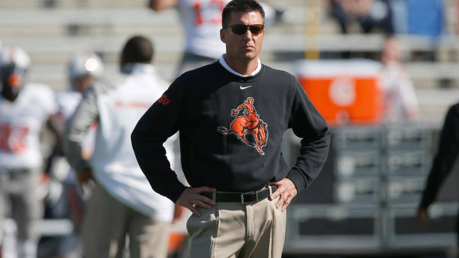 FILE - In this Oct. 11, 2014, file photo, Oklahoma State head coach Mike Gundy watches from the sideline before an NCAA college football game against Kansas in Lawrence, Kan. Gundy wasn't happy with the way his Cowboys played in a lackluster win over Kansas. No. 15 Oklahoma State had better fix their problems soon _ they play at No. 12 TCU on Saturday, Oct. 18. (AP Photo/Orlin Wagner, File)