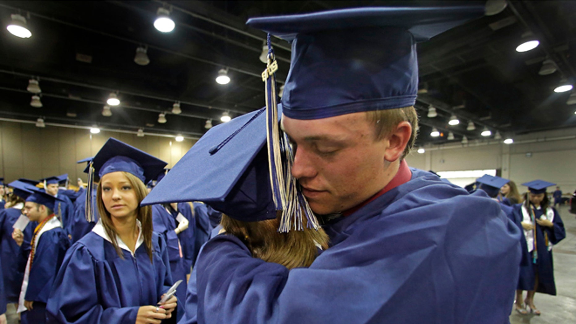 May 25, 2013: Southmoore High School senior Jake Spradling, hugs a classmate as they get ready to attend their commencement ceremony in Oklahoma City five days after a tornado destroyed a large swath of their attendance area in Moore, Okla.