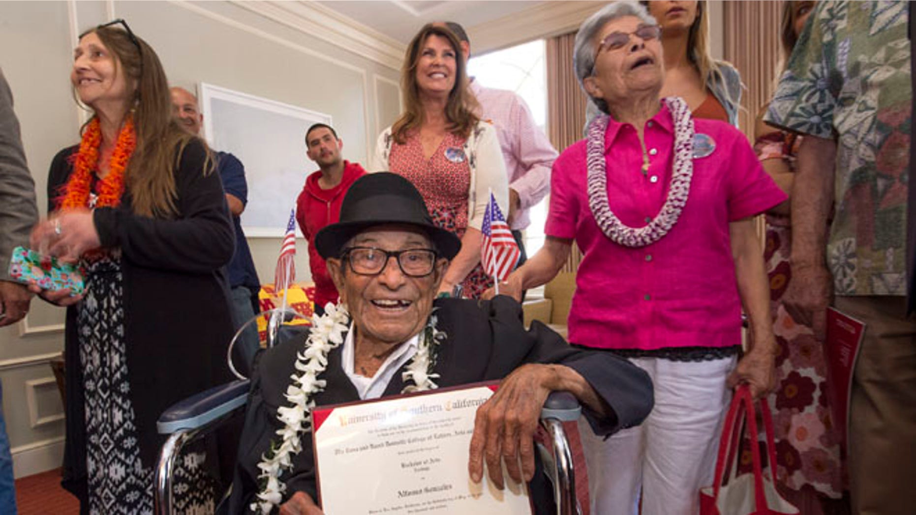 Alfonso Gonzales, 96, University of Southern California's oldest graduating Trojan receives his Bachelor of Science degree in zoology diploma from USC surrounded by family members, as part of the 2016 USC Commencement ceremony, on Friday, May 13, 2016 in Los Angeles. The World War II veteran thought he'd already graduated when he skipped commencement exercises in 1953 because of work obligations. He was founding a soil company that he ran for 55 years. But when relatives recently approached USC about getting a copy of his diploma, they learned he was one unit short. Although the school no longer offers a zoology major, it crafted an independent study course through the gerontology school that included reading, video assignments, visiting other classes, and writing a thesis about his life. (Gus Ruelas/USC via AP)