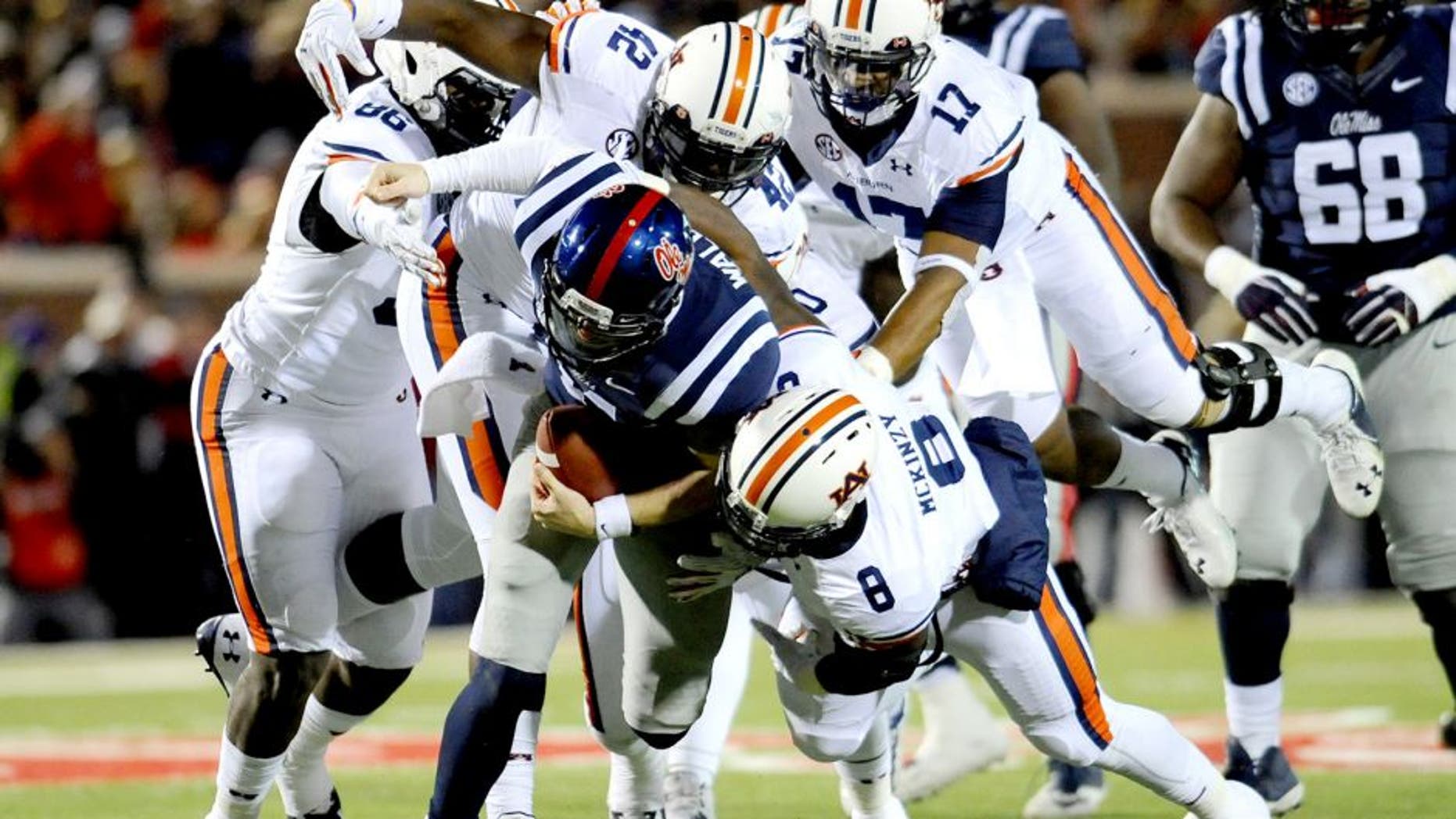 Nov 1, 2014; Oxford, MS, USA; Ole Miss Rebels quarterback Bo Wallace (14) is tackled by Auburn Tigers linebacker Cassanova McKinzy (8) during the second quarter at Vaught-Hemingway Stadium. Mandatory Credit: Shanna Lockwood-USA TODAY Sports