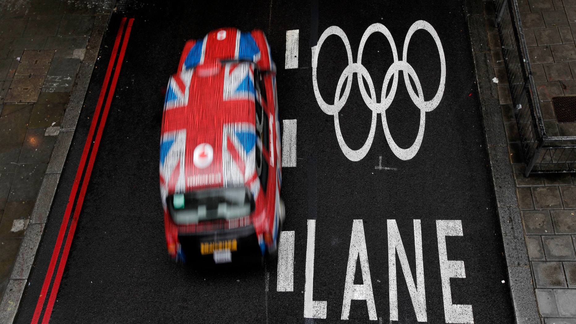 July 16, 2012: A taxi cab drives past an Olympic lane on a street as the city prepares for the 2012 Summer Olympics, central London.