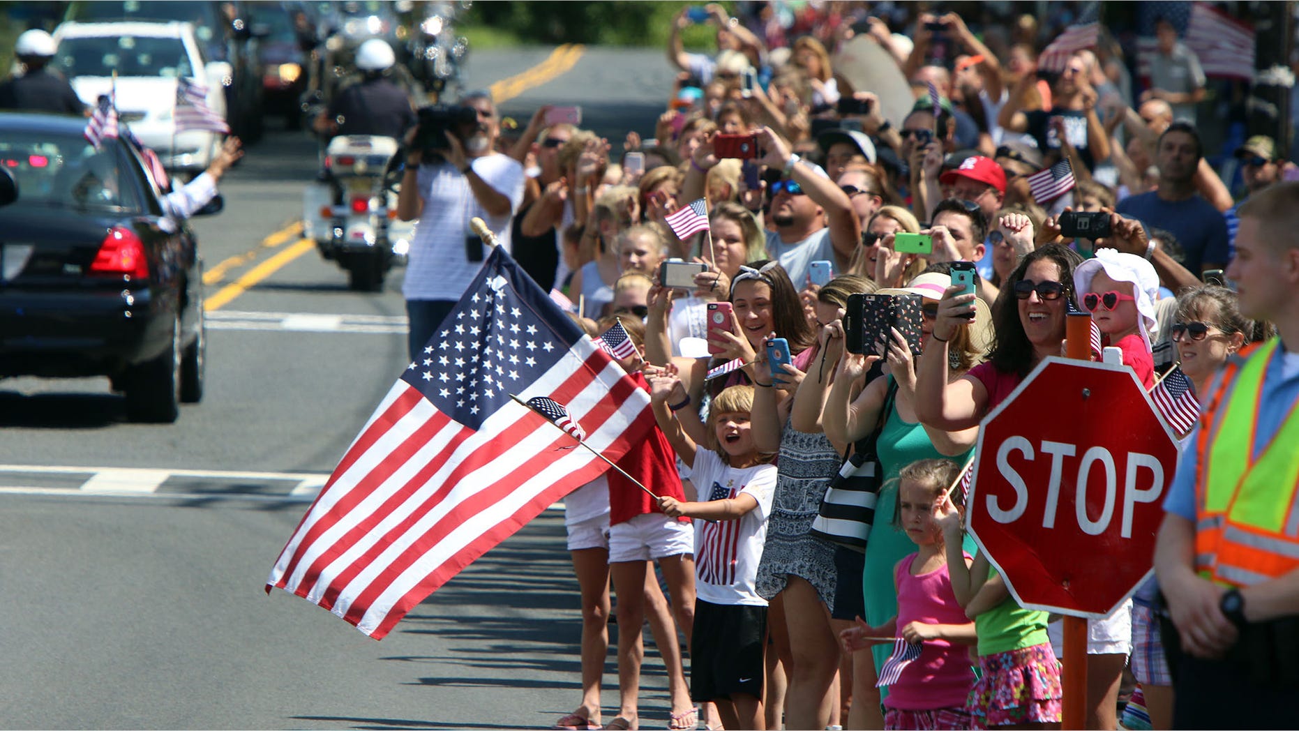 People wave and hold flags during a parade for Olympic gymnast Laurie Hernandez on Saturday, Aug. 27, 2016, in Old Bridge, N.J. (Magdeline Bassett/The Asbury Park Press via AP)