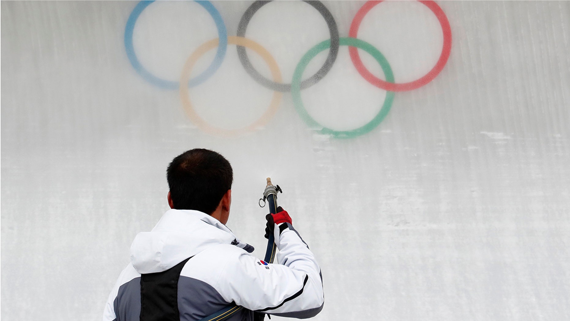 A worker sprays water on the Olympic rings at the Olympic Sliding Centre in Pyeongchang, South Korea.