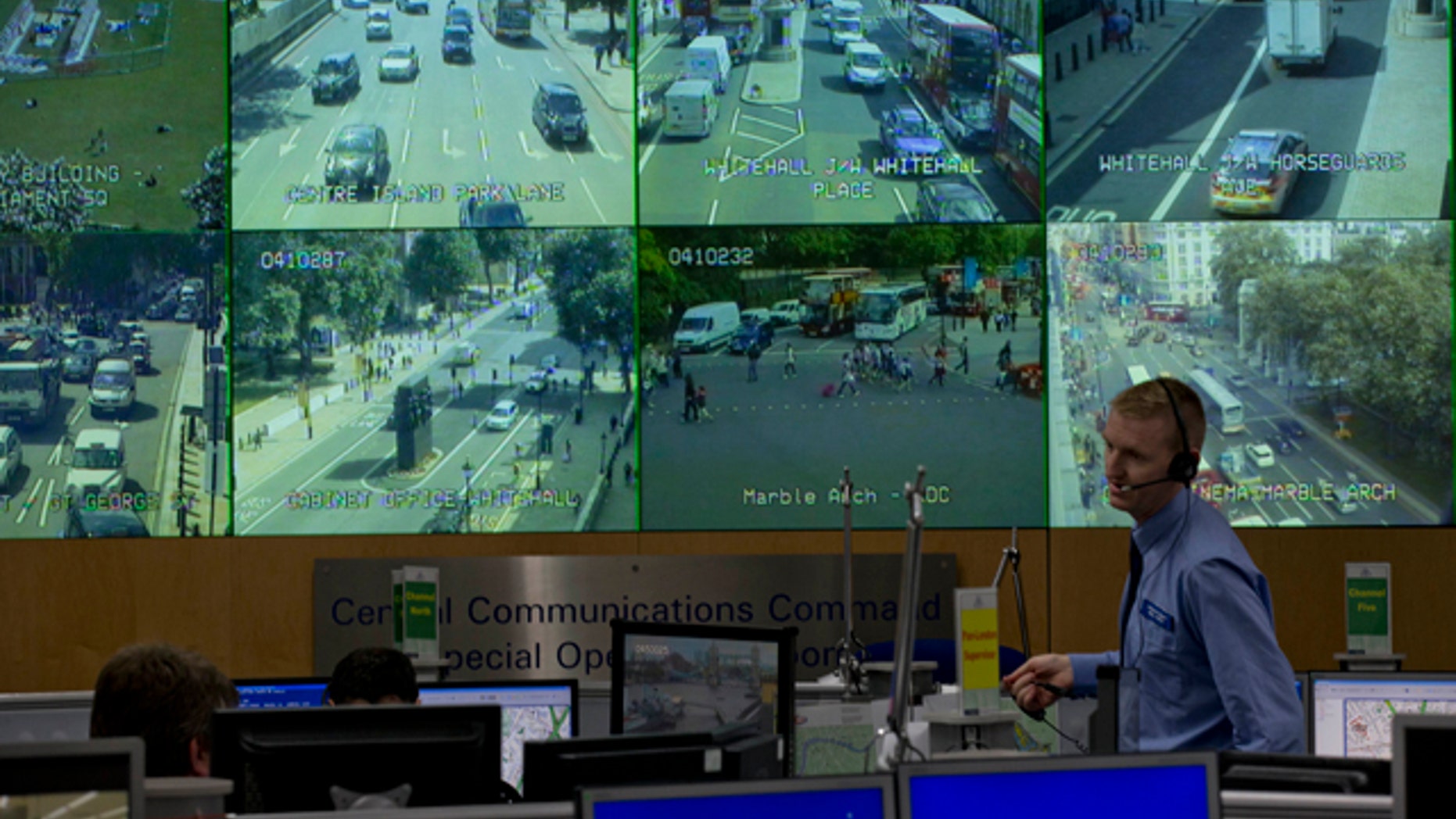 July 19, 2012: A member of police staff stands in front of CCTV screens in London's Metropolitan Police Service Special Operations Room in central London.