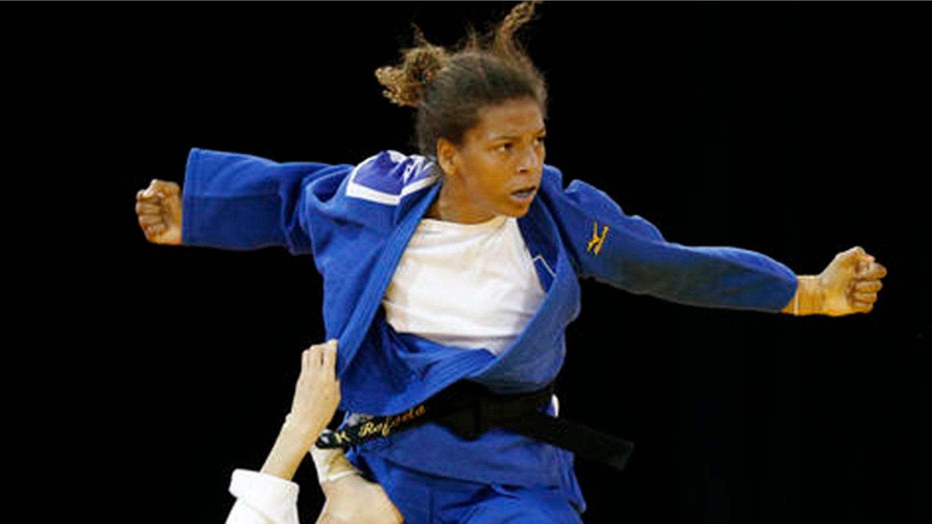 FILE - In this July 12, 2015 file photo, Brazil's Rafaela Silva, top, competes against Venezuela's Anriquelis Barrios during a women's -57kg bronze medal judo match at the Pan Am Games, in Mississauga, Ontario. Silva hoped to get an Olympic gold medal four years ago in London. Disqualified in her Olympic judo match and eliminated from the chance of winning a medal, Brazils Silva thought shed find refuge in sympathetic text messages from fans in her country. Instead, heres what she found: The place for a monkey is in a cage. You are not an Olympian. (AP Photo/Julio Cortez, File)