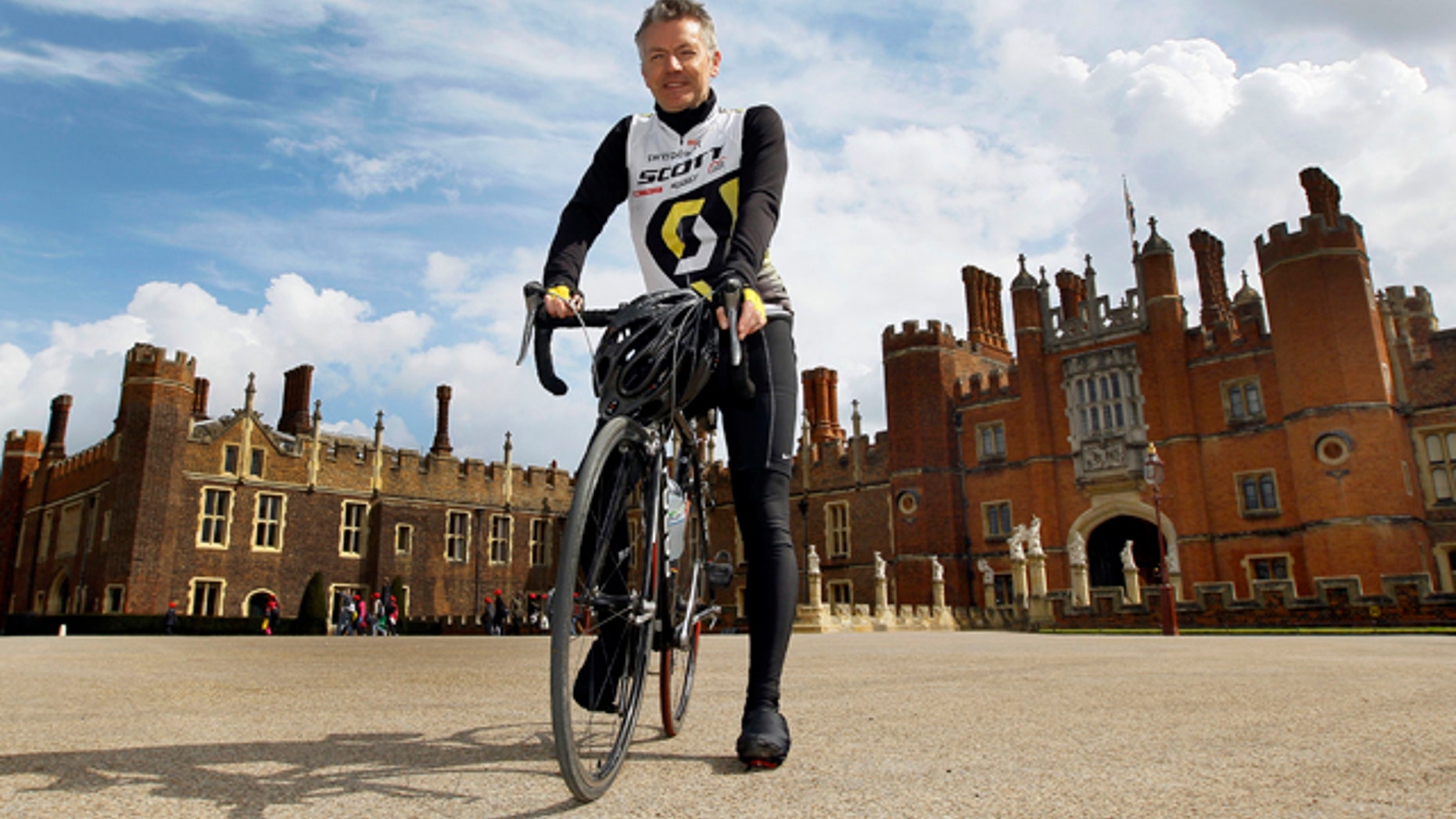 April 20, 2012: In this photo, Surrey County Councils Alan Flaherty, who has been involved in designing the Olympic road cycle course, and helping athletes to test it out, poses for a photograph in front of Hampton Court Palace, Hampton, England.