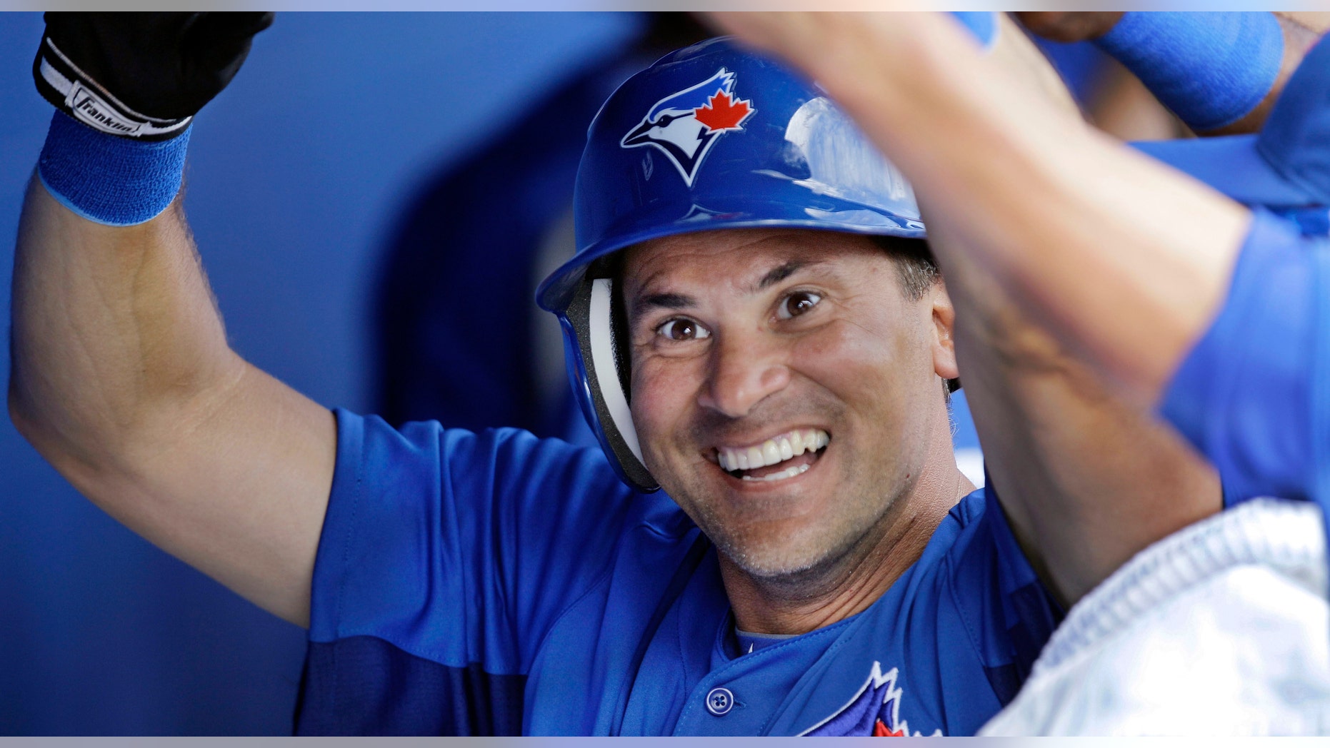 El jugador venezolano de los Azulejos de Toronto, Omar Vizquel, sonríe tras anotar una carrera en un partido de pretemporada el sábado, 24 de marzo de 2012, en Dunedin, Florida. (AP Photo/Kathy Willens)