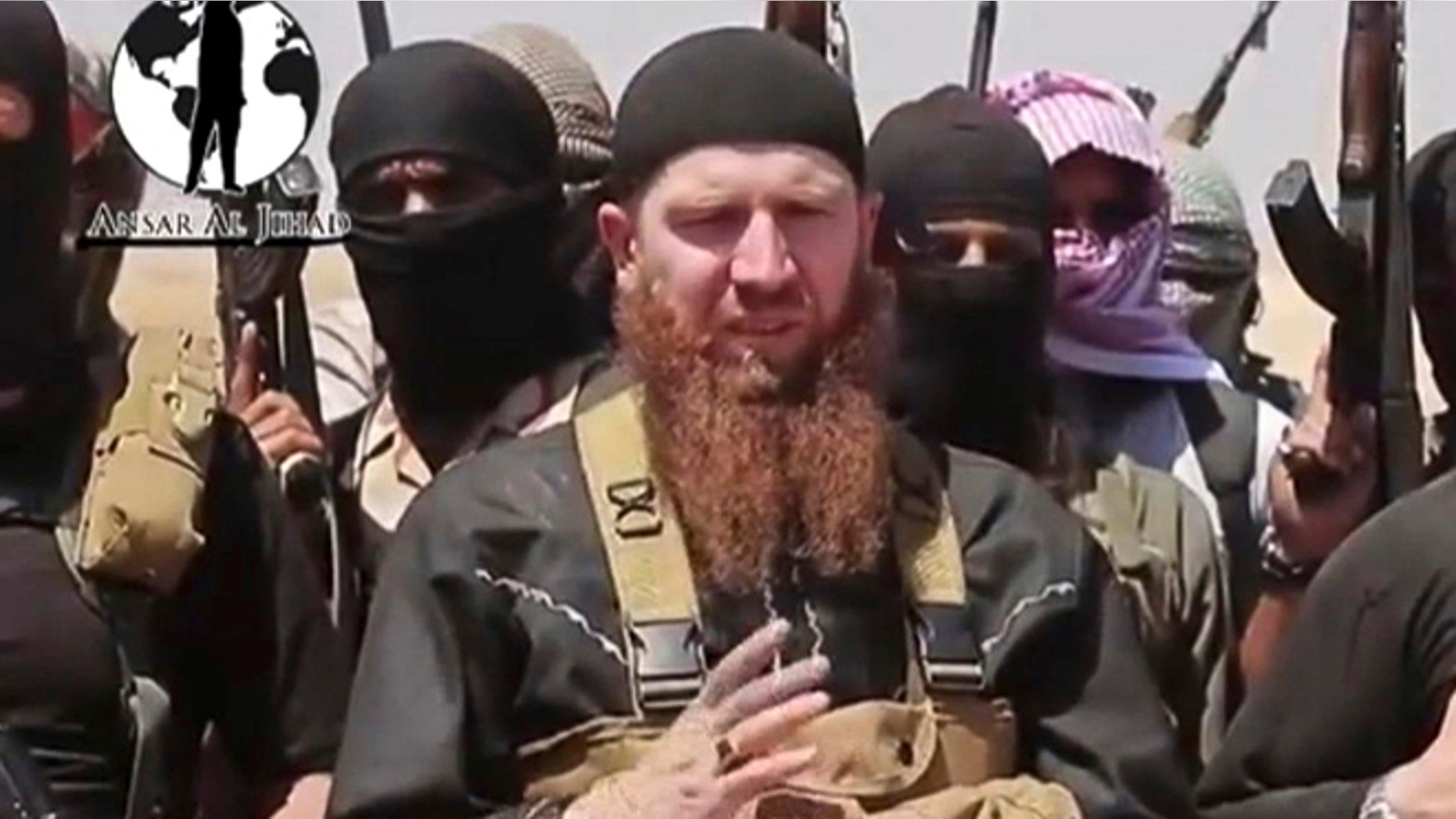 This image made from undated video posted during the weekend of June 28, 2014 on a social media account frequently used for communications by the Islamic State of Iraq and the Levant (ISIS), which has been verified and is consistent with other AP reporting, shows Omar al-Shishani standing next to the group's spokesman among a group of fighters as they declare the elimination of the border between Iraq and Syria.