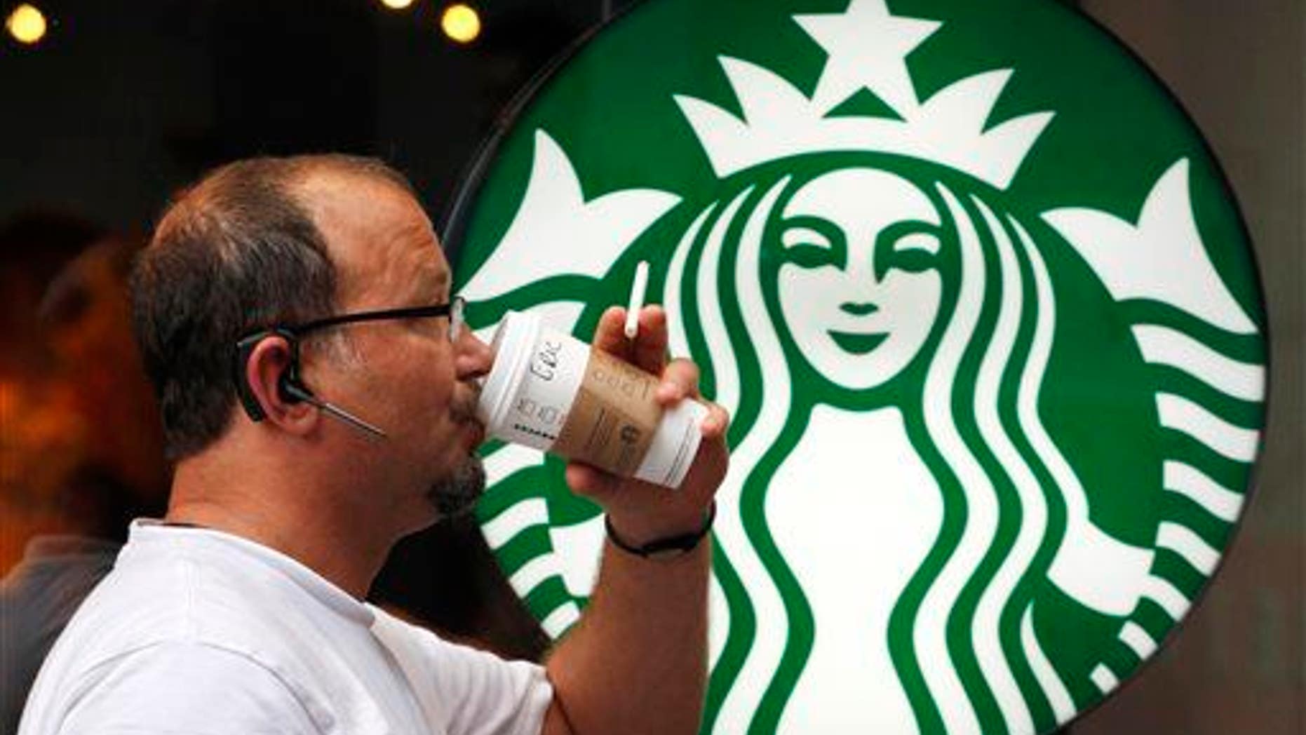In this July 11, 2013, file photo, a man drinks a Starbucks beverage in New York.